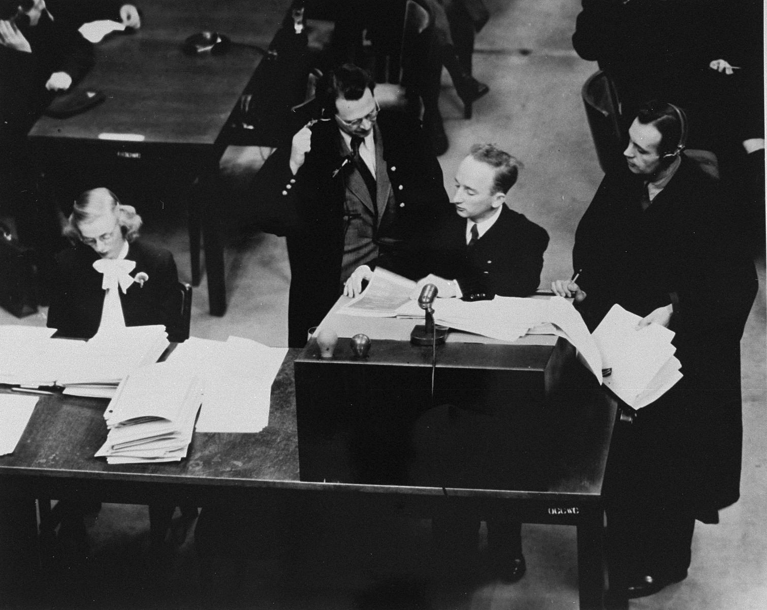 Chief prosecutor Benjamin Ferencz presents documents as evidence at the Einsatzgruppen Trial.  

Ferencz is flanked by German defense lawyers, Dr. Friedrich Bergold (right, counsel for Ernst Biberstein) and Dr. Rudolf Aschenauer (left, counsel for Otto Ohlendorf), who are protesting the introduction of the documents as evidence.