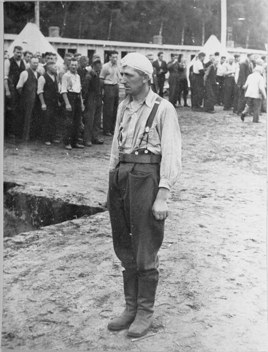 A Polish POW stands at attention in the roll call area (Appellplatz) at the Stutthof concentration camp.