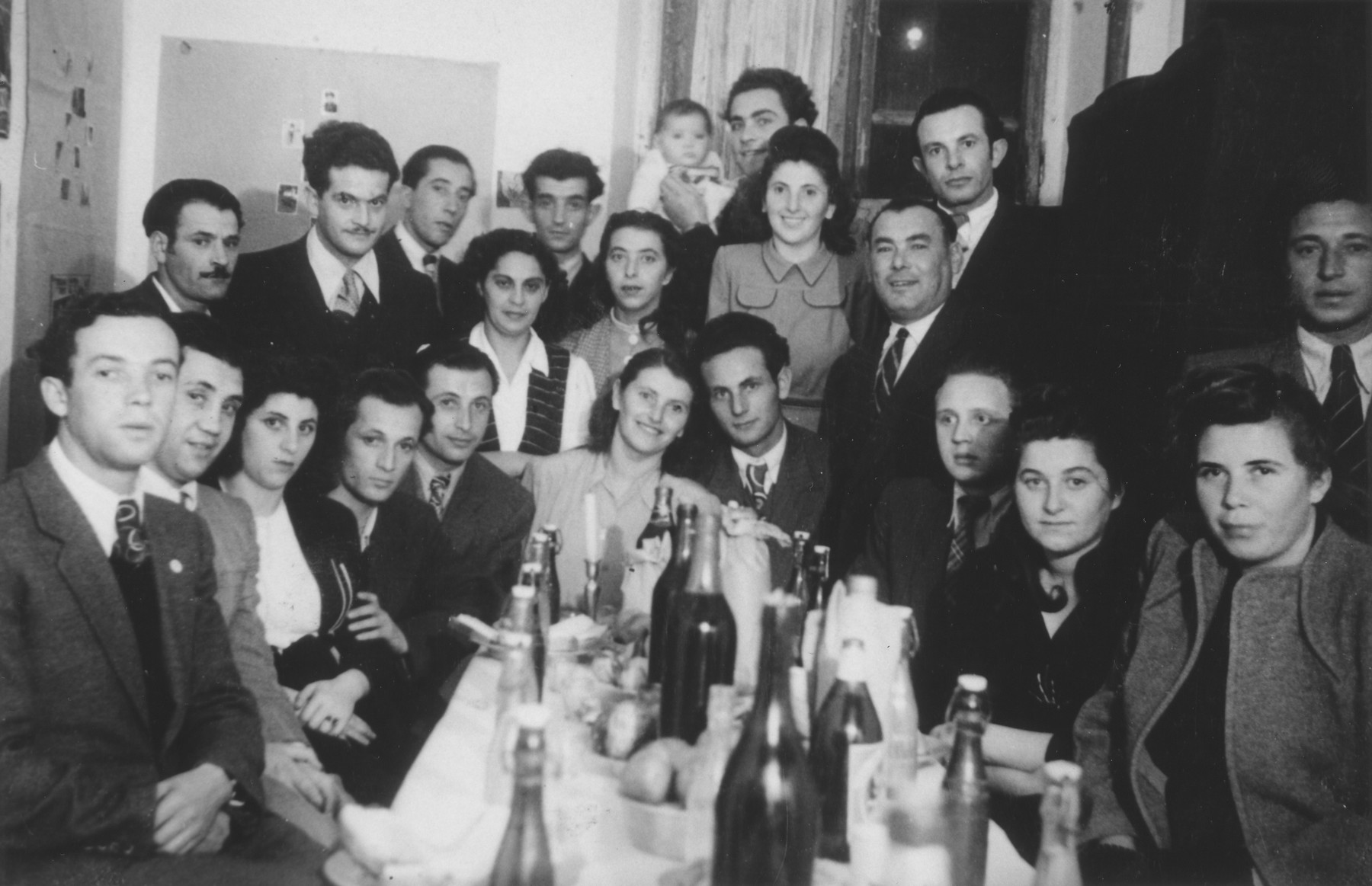 A group of friends celebrates the wedding of  Jacob and Miriam Schwimmer in the Bari dispaced persons camp. 

Among those pictured is Jerome (Jacob) Hollander, seated second from the left.
