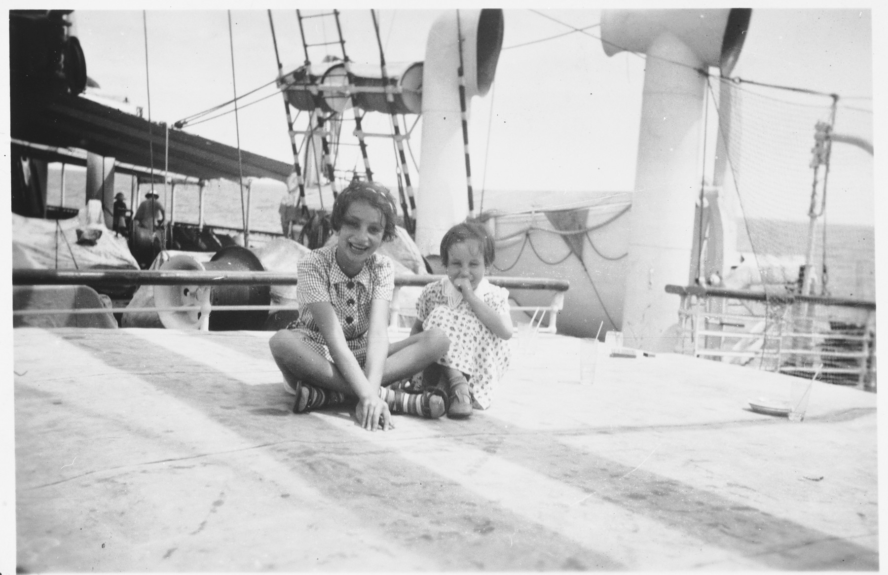 Two Jewish refugee children sit on the deck of the Usambara while en route to Africa. 

Pictured are Gisela (right) and Inge Berg (left).