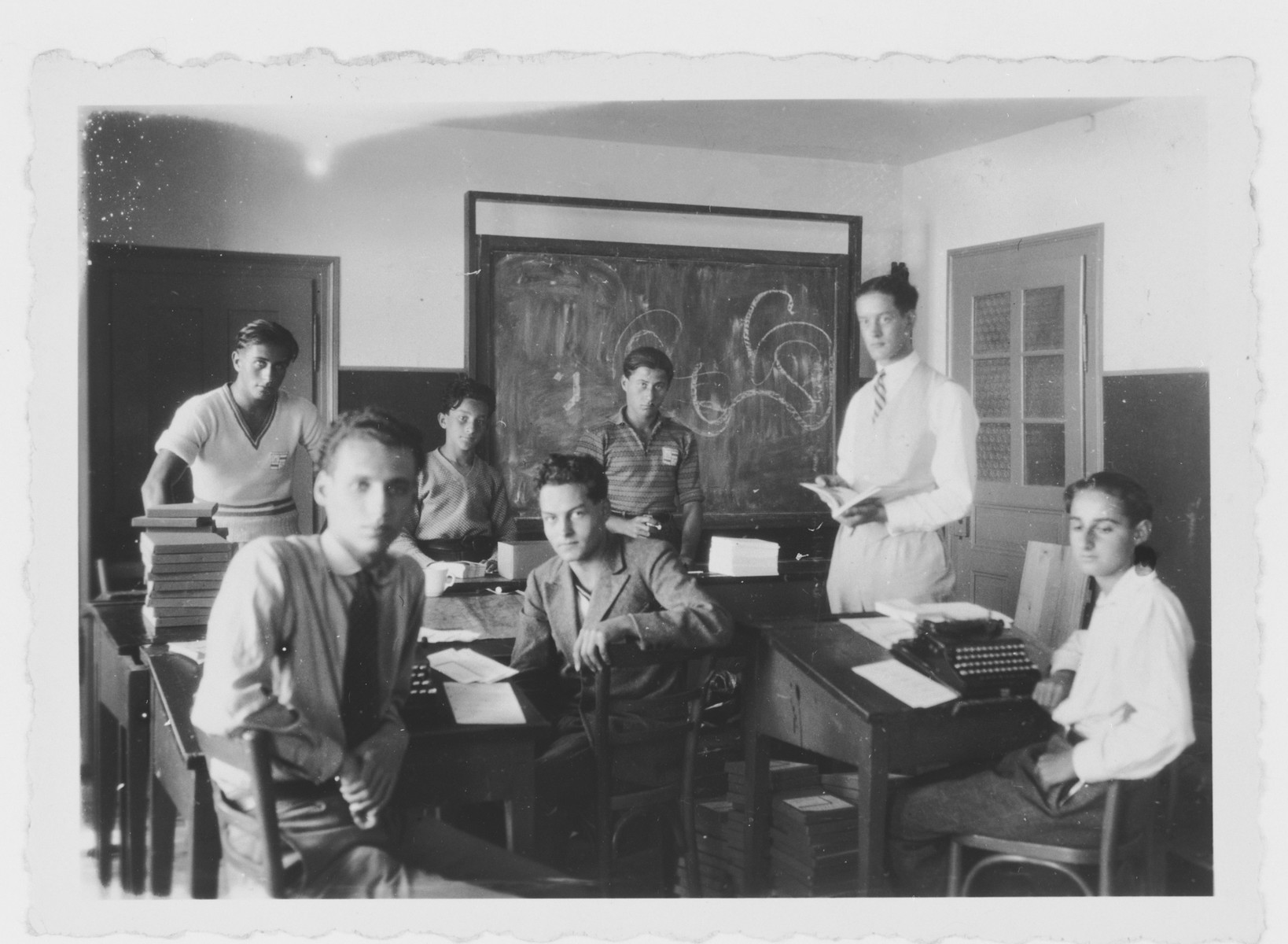 Italian teenagers sit by their desks in their high school classroom.

Mario Fabini is in the center in a suit.