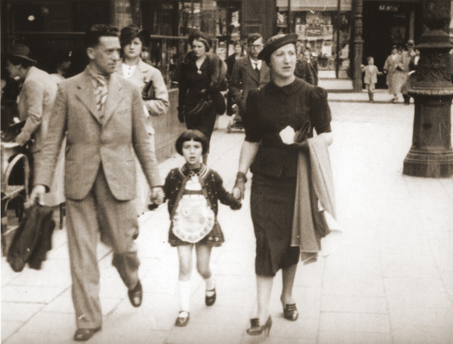 Michael and Manja Schadur stroll along a commercial street in Antwerp with their daughter. Benita.