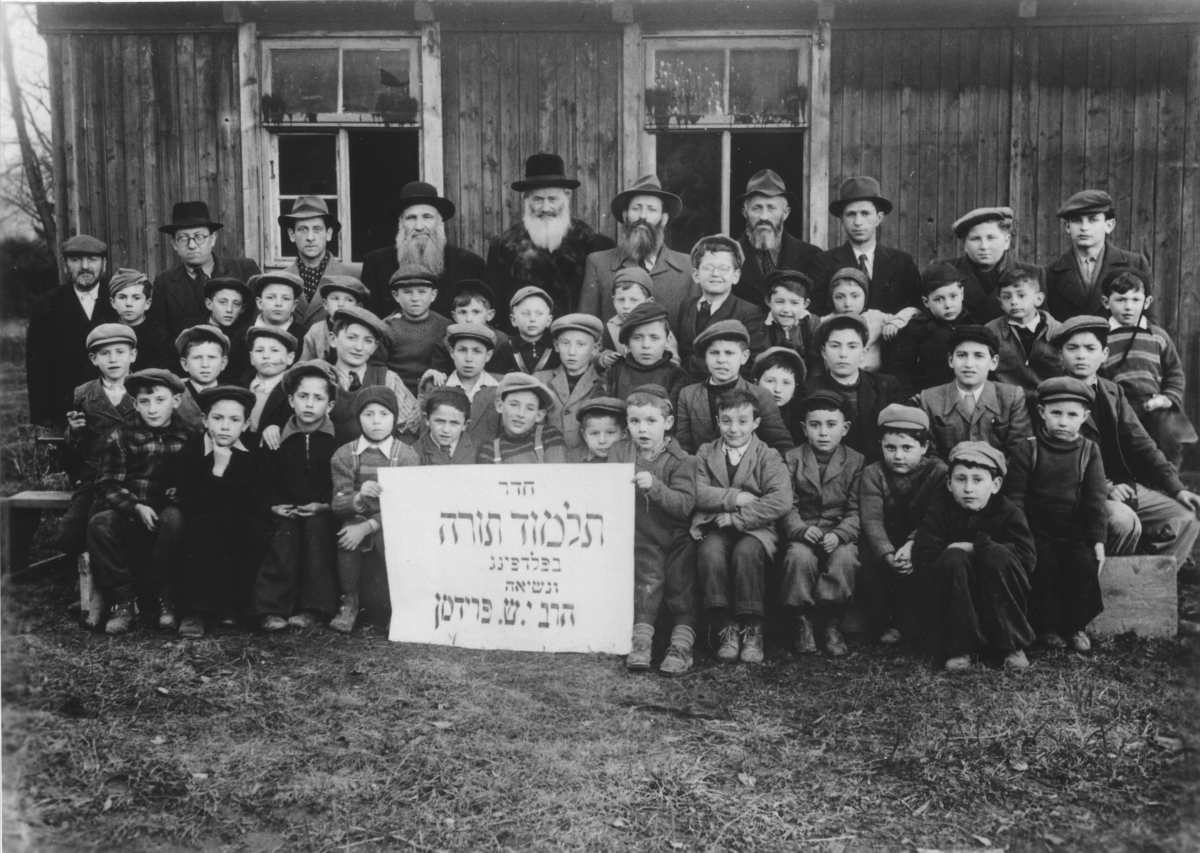 Group portrait of students and teachers of the Talmud Torah (religious primary school) in the Feldafing displaced persons camp.

Among those pictured is Srulek Rajs. Pictured in the second row, fourth from the right is Manny Mendel Glass