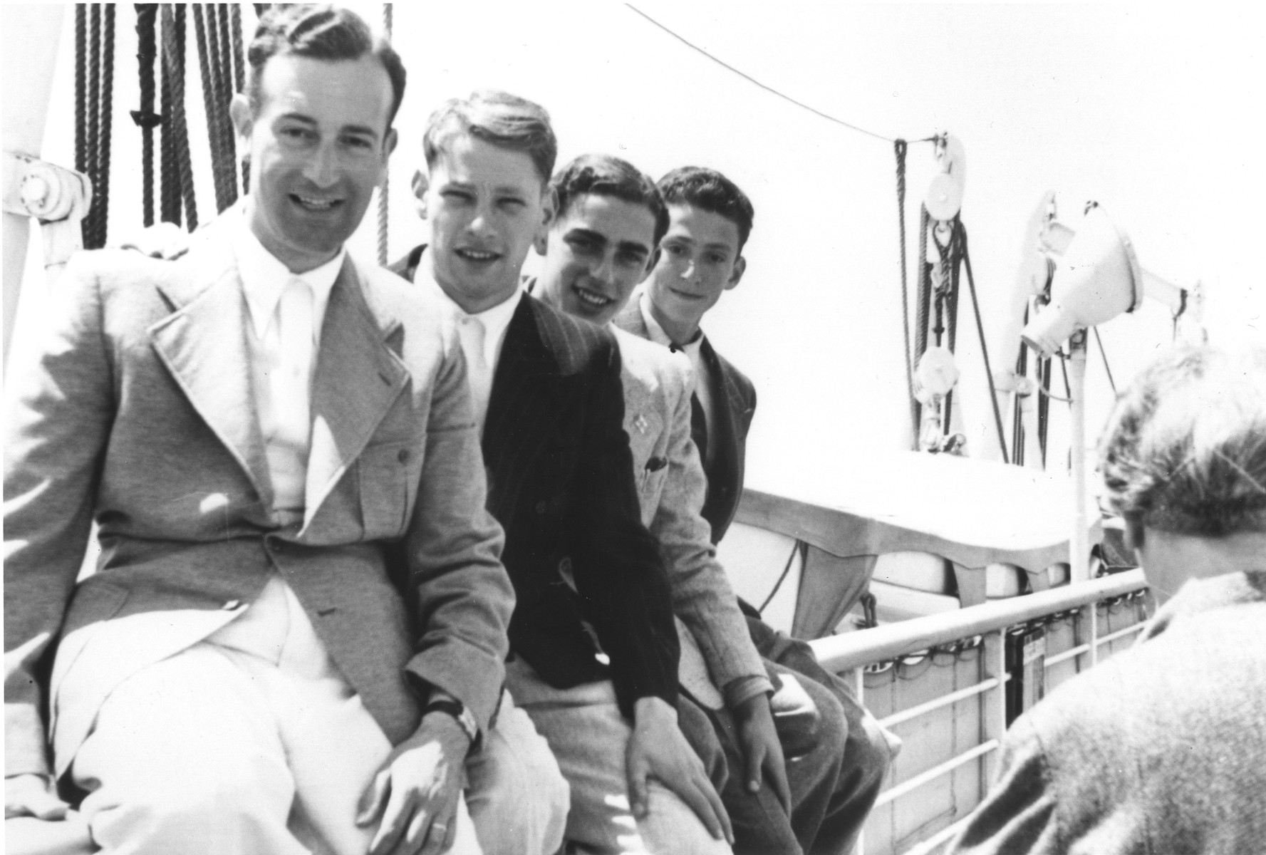 Four young Jewish refugees sit on the railing along the deck of the MS St. Louis.

Pictured from left to right are Werner Lenneberg, Fritz Hilb, Fritz Buff and unknown.