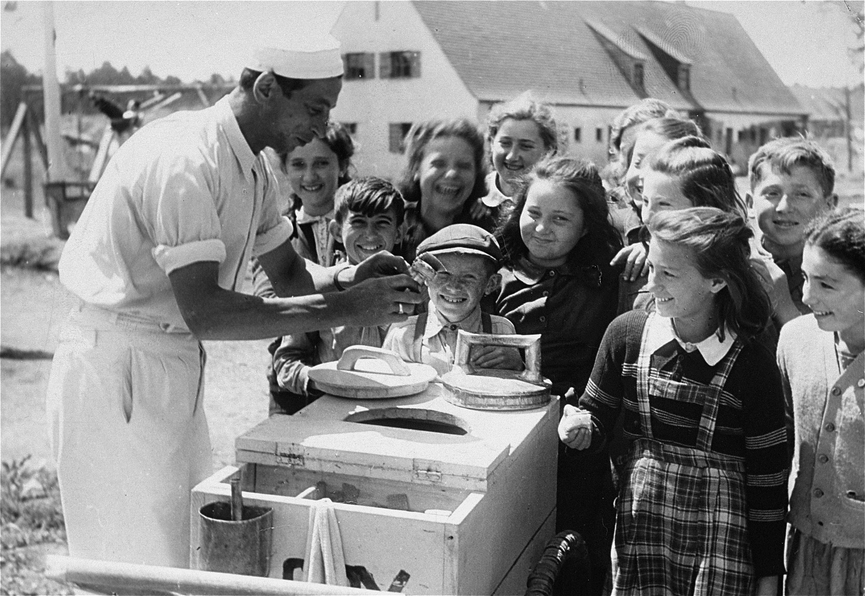 Children wait for ice cream in the Foehrenwald DP camp.  

Chaia Libstug is on the extreme right and Nocham Swidler is in the front center.  Paula Lebovics is second from the right in the front.