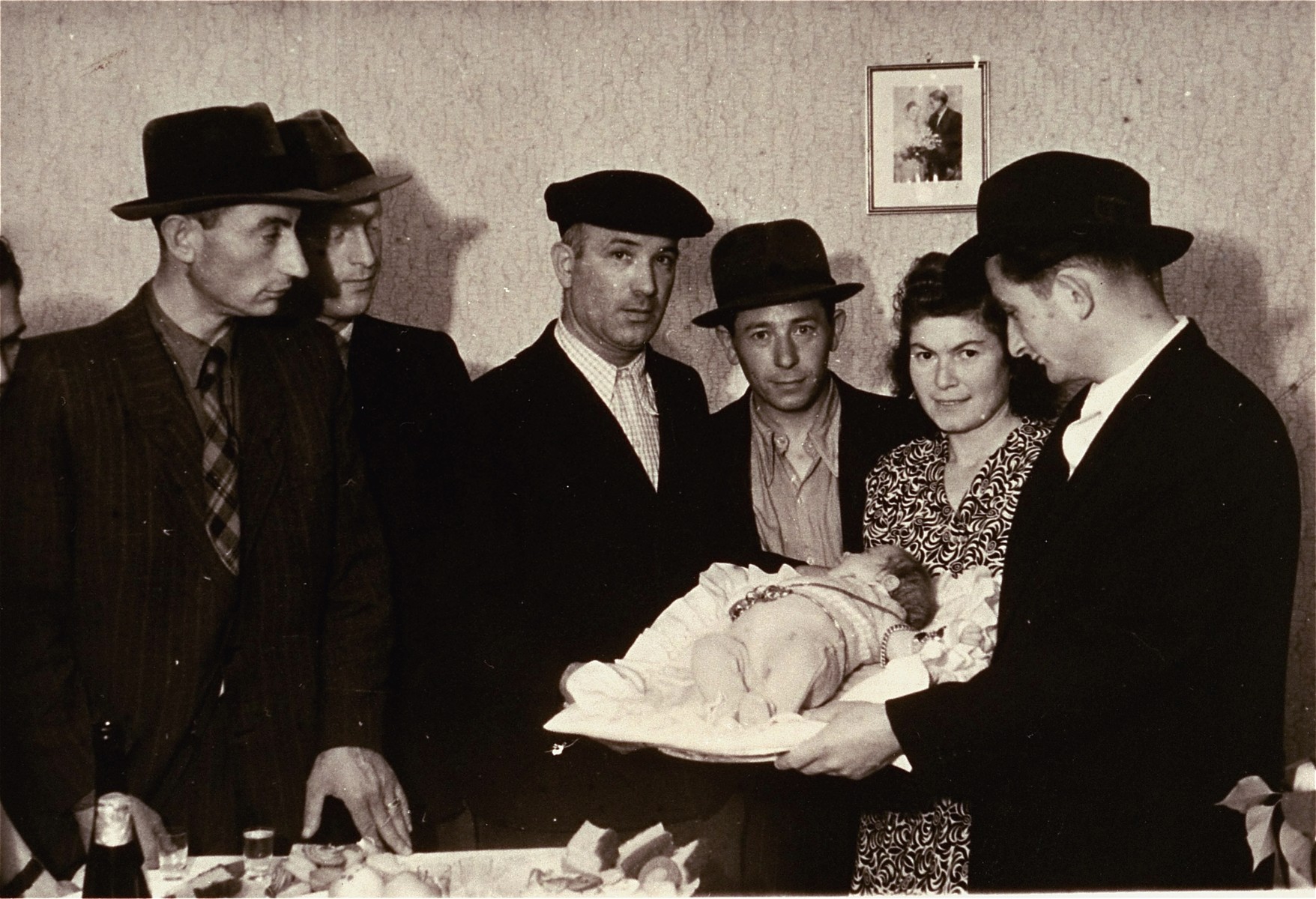 A Jewish couple in the Zeilsheim displaced persons camp with their newborn son celebrating the ceremony of Pidyon Haben, the symbolic redemption of a firstborn son with silver coins - sometimes replaced with jewelry - a tradition that dates back to antiquity and the Temple in Jerusalem.