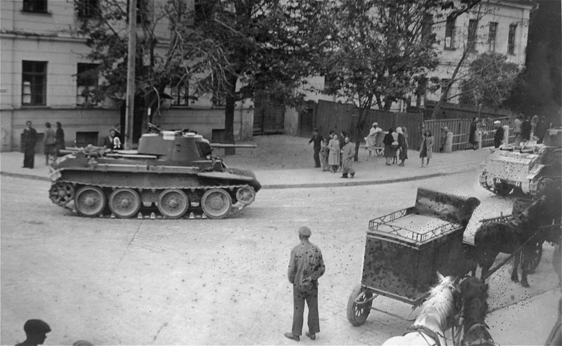 Russian tanks roll through the streets of Kaunas during the Soviet occupation of Lithuania.  

This photo was taken through a hole in a piece of paper that was used to cover a window.