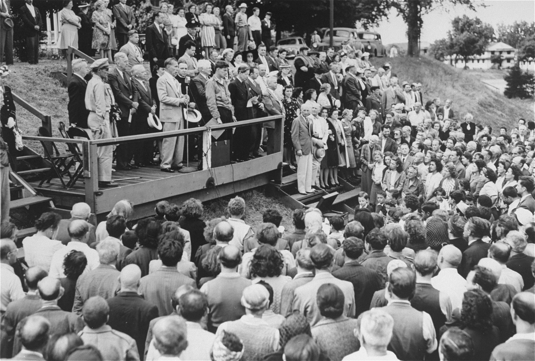 The day after their arrival at Fort Ontario Father J.J. Davem pronounces an invocation at a welcome ceremony for the European refugees.

Among those pictured are Zdenka Levi's brother from Yugoslavia, and Fred Baum, the camp interpreter.