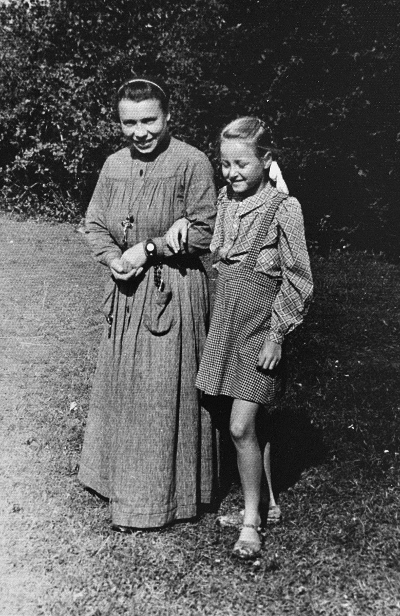 Selma Schwarzwald poses with a novice nun at a summer camp for orphaned children at a convent in Rabka, Poland.

Selma is a Jewish child who lived in hiding as a Polish Catholic during the war.