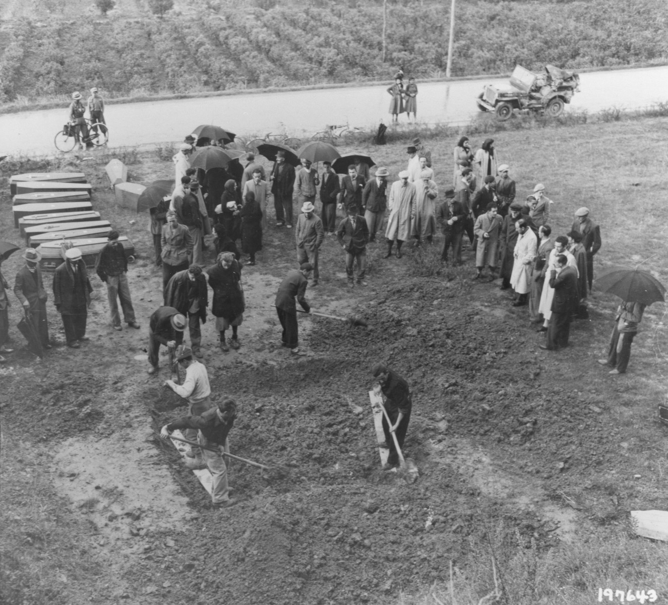 Italian civilians exhume a mass grave containing the bodies of 38 Italians shot by German forces.  

The victims were chosen at random and killed in reprisal for the murder of an Italian Fascist by partisans in August 1944.  A young Italian woman who protested the killings to the Germans was shot along with the other hostages.