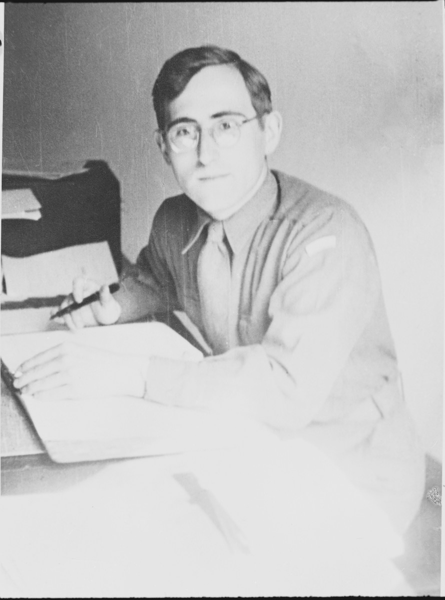 Portrait of Gad Beck sitting at a desk in a displaced persons camp.