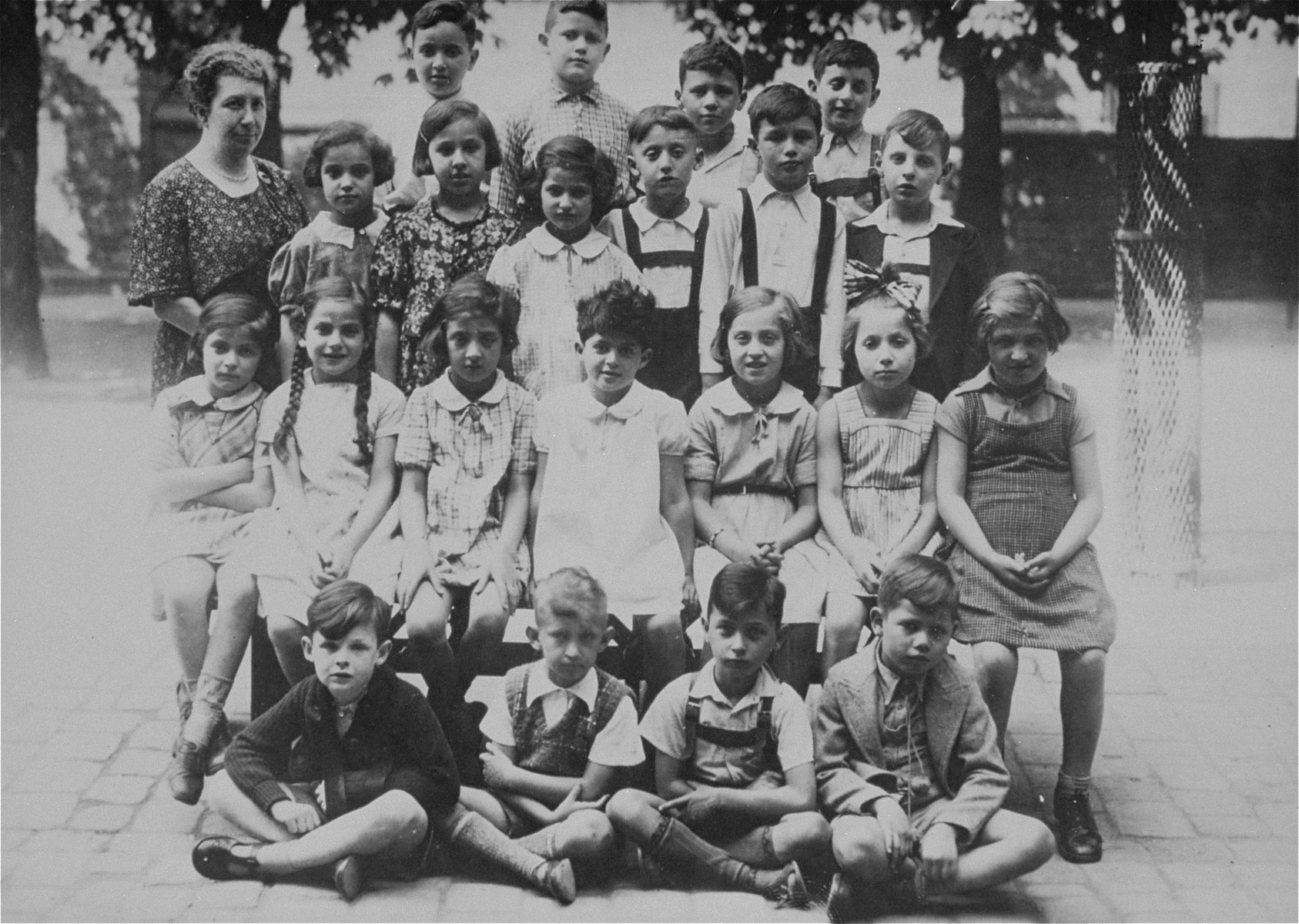 Group portrait of pupils in the first grade at a Jewish school in Karlsruhe, Germany that had been relocated to one floor at the 'Holzbodengymnasium' a special school for mentally disabled children. 

Among those pictured is the teacher, Flora Hirsch.