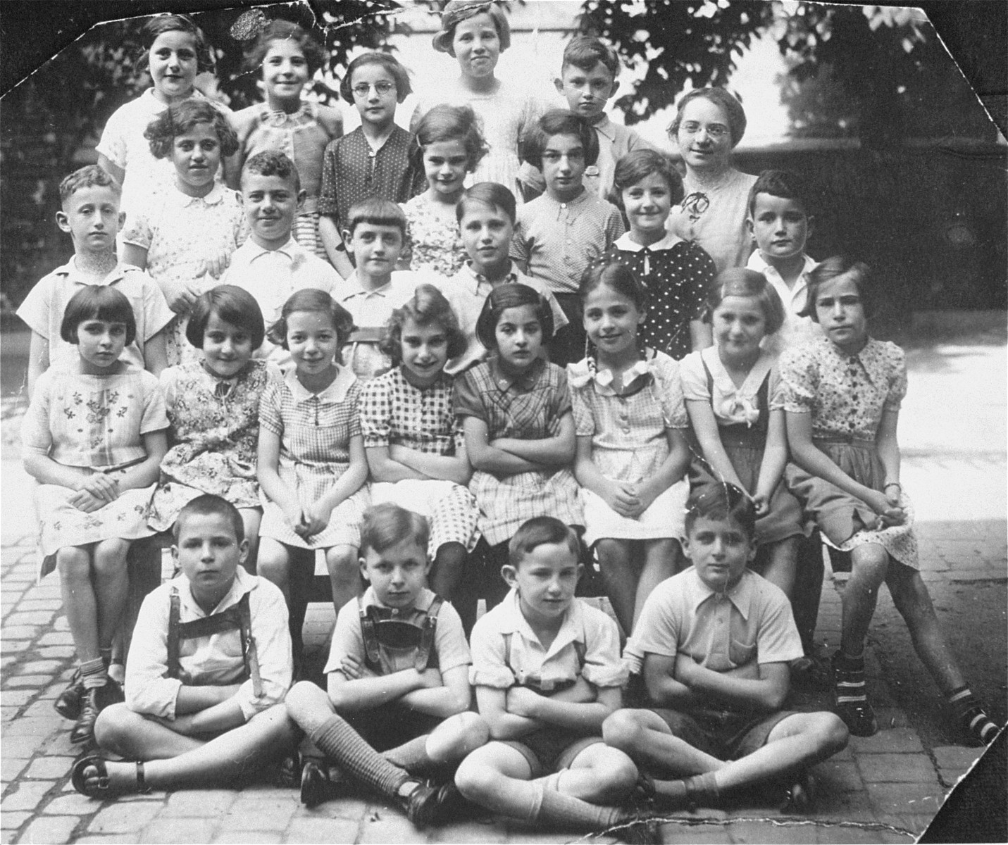 Group portrait of pupils in the third grade at a Jewish school in Karlsruhe, Germany that had been relocated to one floor at the 'Holzbodengymnasium' a special school for mentally disabled children. 

Among those pictured is the teacher, Caecilie Schweizer.