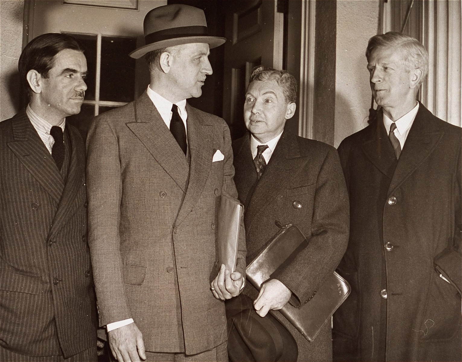 Members of the President's Advisory Committee on Political Refugees pose with Under Secretary of State Sumner Welles after their meeting at the White House with Roosevelt.

Pictured from left to right are: Hamilton F. Armstrong, Sumner Welles, committee secretary George L. Warren, and committee chairman, James McDonald.

Original  AP caption reads: "With tense relations existing between nations over handling of minorities, the National Advisory Committee on Refugees reported to President Roosevelt in Washinton, D.C. Nov. 16 at the White House.  From the left: Committeeman Hamilton F. Armstrong; Under Secretary of State Sumner Welles who sat in on the meeting; Secretary of Committee George L. Warren and Chairman James Mac Donald [sic]."