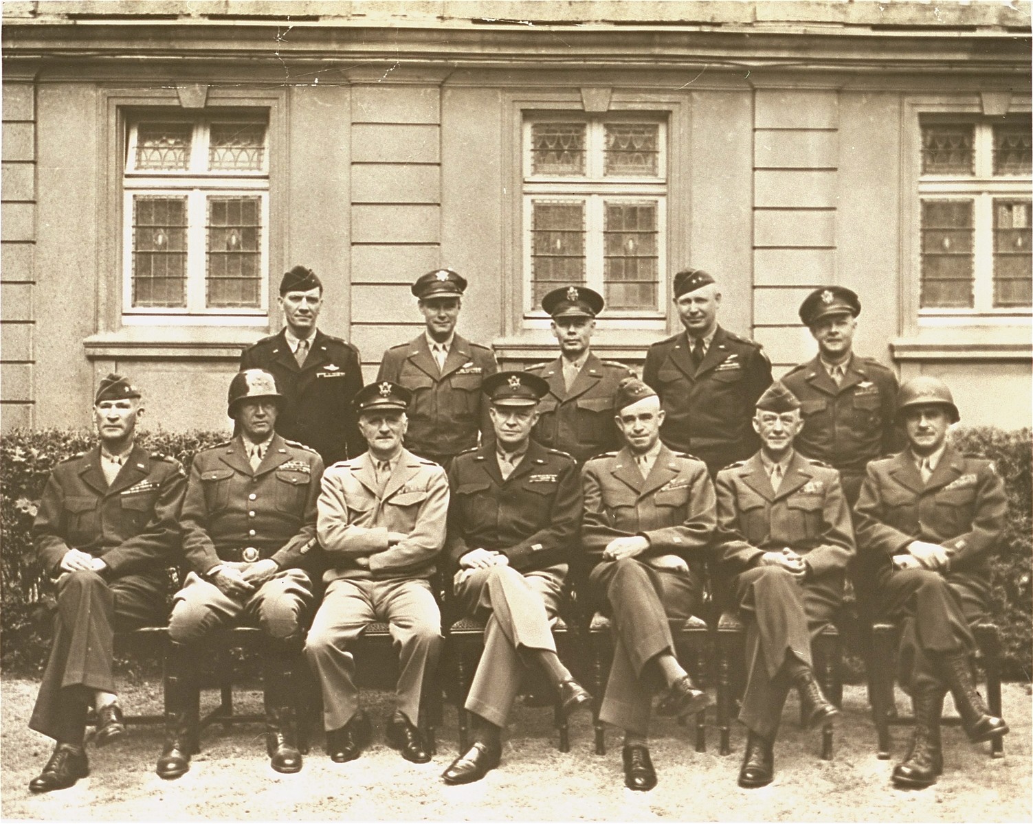 American generals who helped pave the way to victory are photographed during a victory meeting at Gen. Omar N. Bradley's 12th Army group headquarters. 

Seated left to right: Lt. Gen. Wm. H. Simpson, Gen. George Patton, Jr., Gen. Carl A. Spaatz, Gen. Dwight D. Eisenhower, Gen. Omar N. Bradley, Gen. Courtney H. Hodges, Lt. Gen. Leonard T. Gerow. Standing left to right: Brig. Gen. Ralph F. Stearley, Lt. Gen. Walter B. Smith, Maj. Gen. Otto P. Weyland, Brig. Gen. Richard E. Nugent.