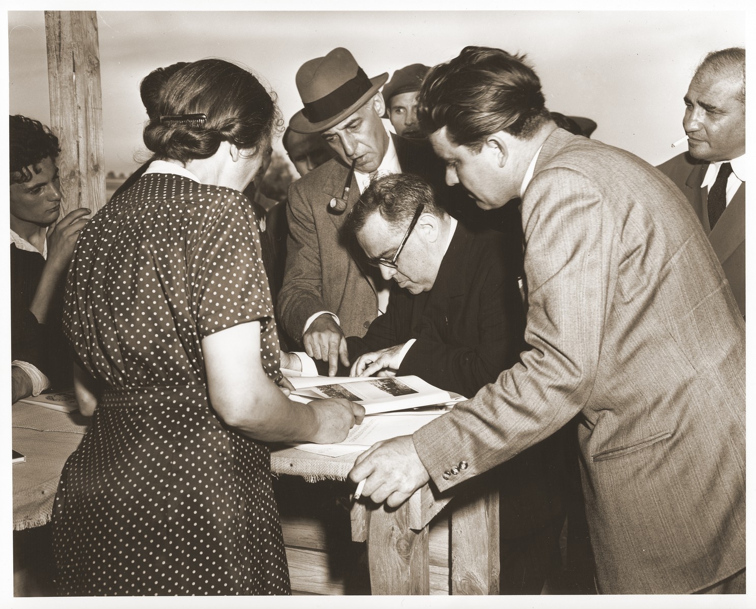 A survivor of the Lidice massacre shows Fiorello LaGuardia an album of photographs depicting the Nazi atrocity of June 1942, during an official visit by the UNRRA director to Lidice.

Also pictured is Laurence Steinhardt, U.S. Ambassador to Czechoslovakia (next to LaGuardia smoking a pipe), and Vaclav Majer, Czech minister of Food (to the right of LaGuardia).