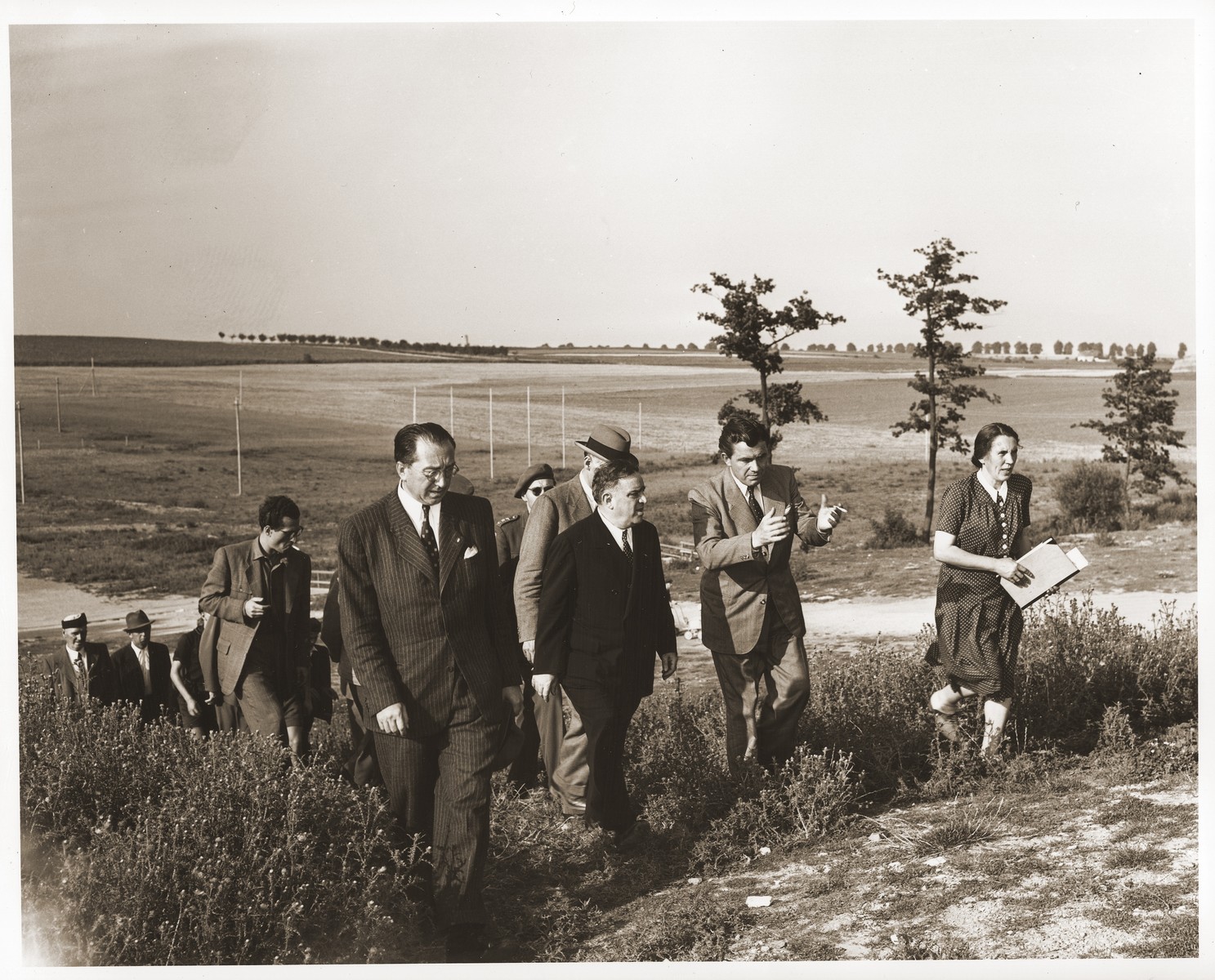 During an official visit to Lidice UNRRA Director General Fiorello La Guardia visits the site of the Nazi massacre of Czech civilians which was perpetrated in June 1942 in retaliation for the assassination of Reinhard Heydrich, then Reichsprotektor of the Protectorate of Bohemia and Moravia.

LaGuardia is accompanied by Vaclav Majer (left), Czech Minister of Food, Mr. Nemec, Czech Minister Plenipotentiary and government delegate to UNRRA, and Laurence Steinhardt (partially concealed behind LaGuardia), U.S. Ambassador to Czechoslovakia.