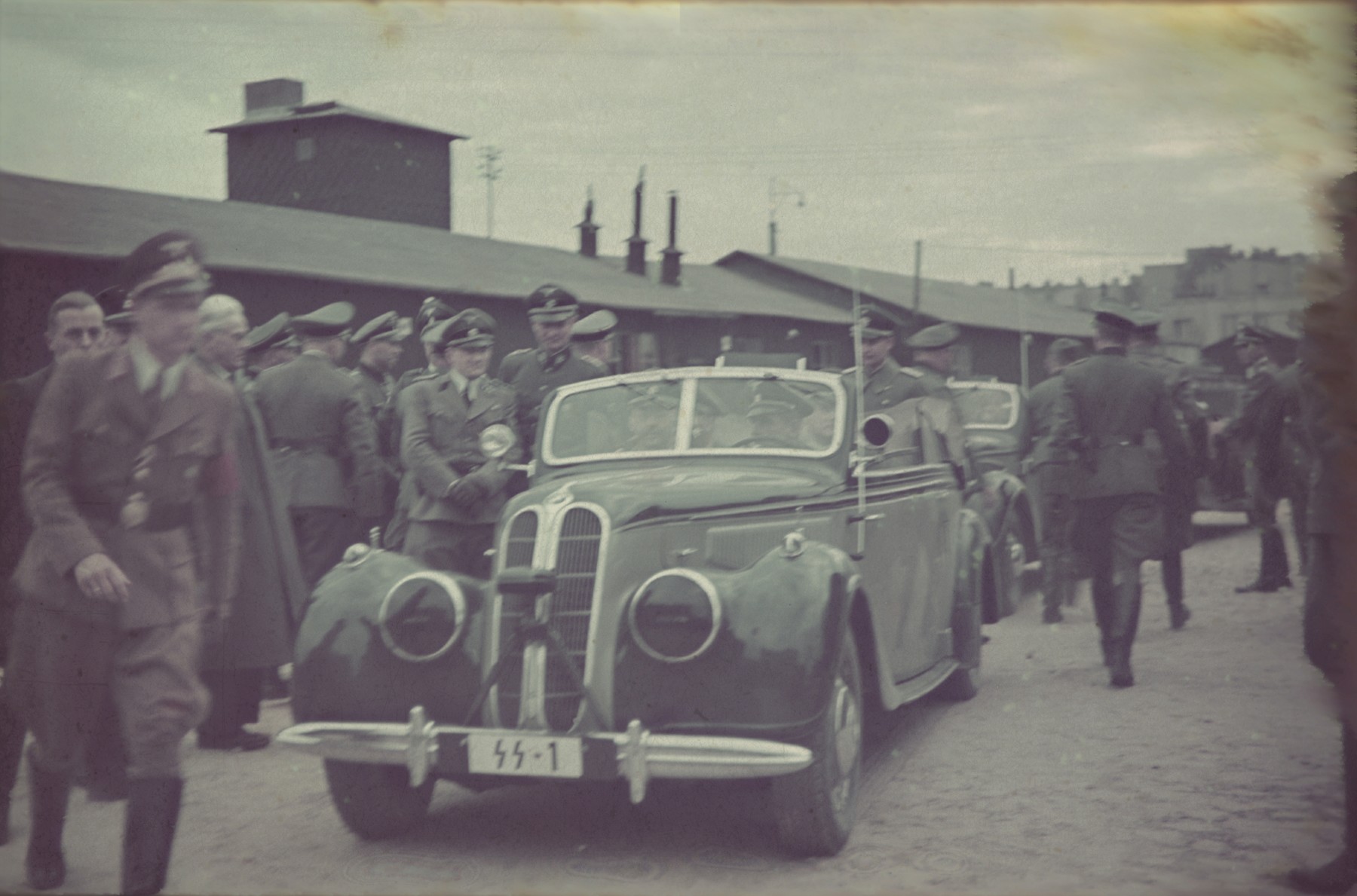 An official visit of Heinrich Himmler in the Lodz Ghetto. Mordechai Chaim Rumkowski, head of the Jewish council, greets the Nazi officials. Standing to the right of the car is Karl Wolff.