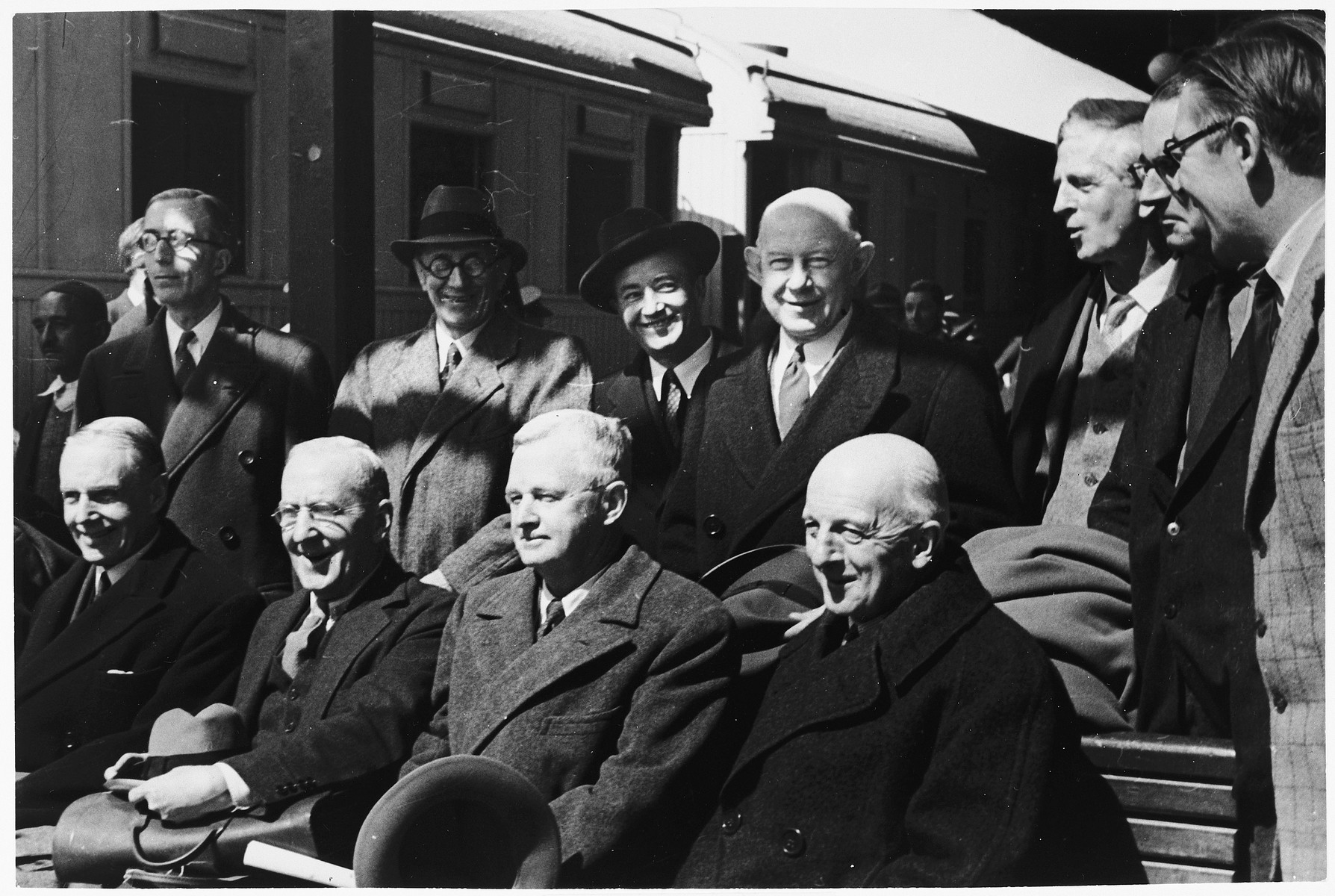 Group portrait of members of the Anglo-American Committee of Inquiry on Palestine after their arrival at the train station in Jerusalem.

Pictured seated from right to left are: Judge Joseph Hutcheson (American chairman), Frank Singleton (British chairman), Frank Buxton (U.S.), and William Phillips (U.S.).  Standing from right to left are: R.H.S. Crossman (UK), R.E. Manningham-Buller (UK), James G. McDonald (U.S.), Frank Aydelotte (U.S.), Bartley Crum (U.S.), Sir Frederick Leggett (UK), and W.F. Crick (UK).  The twelfth member of the committee was Lord Morrison (UK).