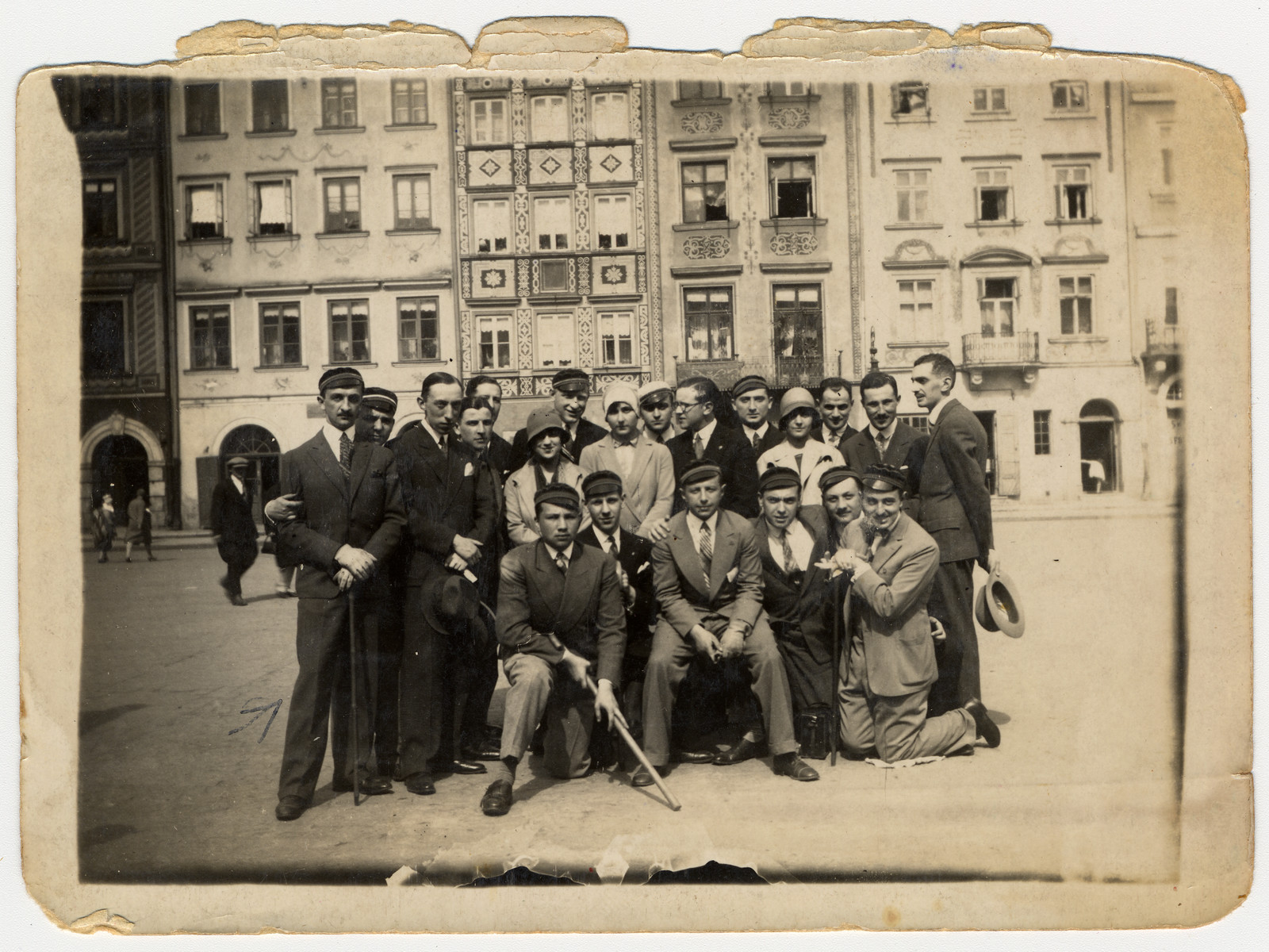 A group of friends, many of whom are wearing university caps, pose for a group portrait on a street in Warsaw.

Among those pictured is Henryk Rothard (far left), the step-father of the donor.