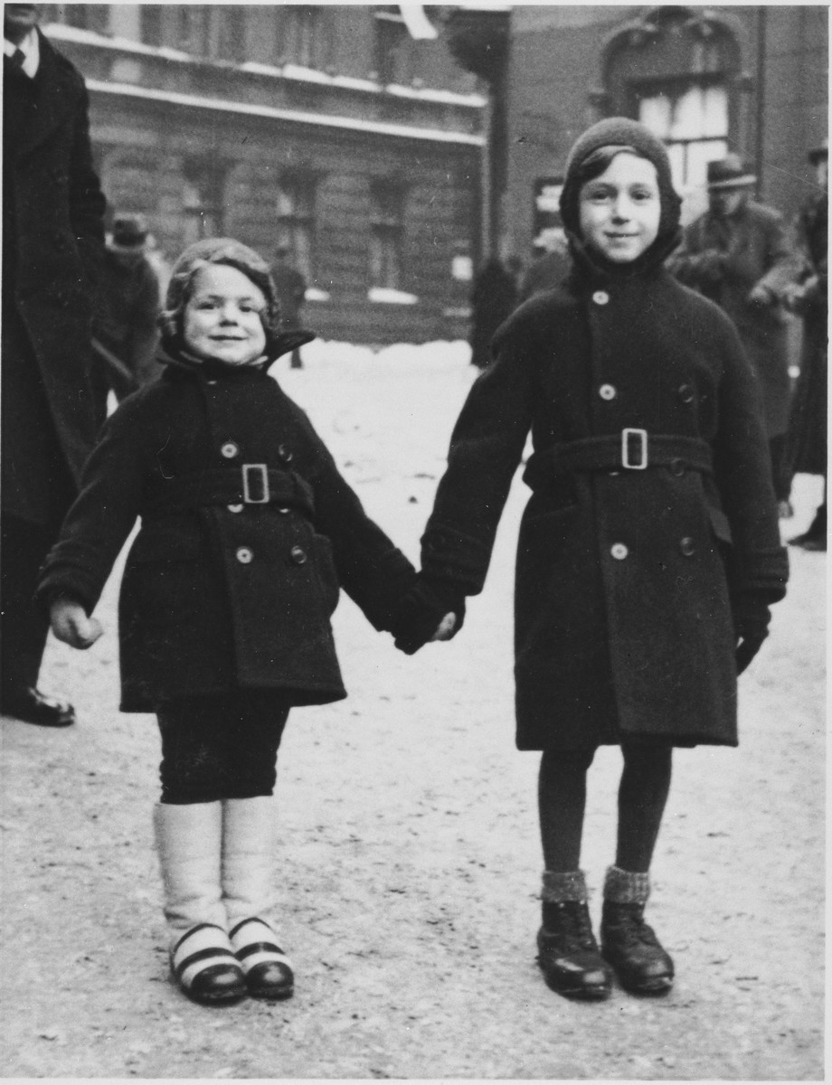 Kazik and Annetta Kohane, dressed in winter coats, stand on the street outside their home in Katowice.
