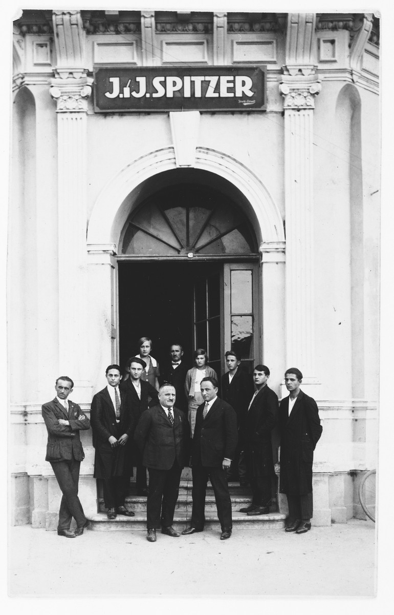 Employees of the J.J. Spitzer textile importing firm pose at the entrance to their building in Osijek, Croatia.  

Marko Spitzer and his father stand in the center.