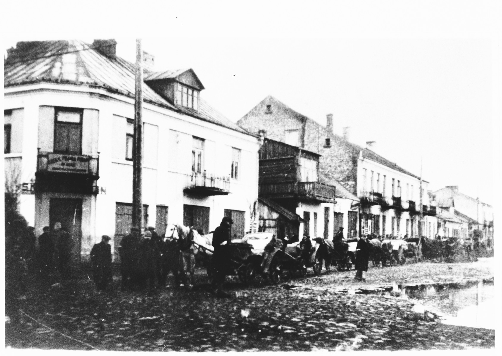 Horse and wagons line the street of an unidentified ghetto.