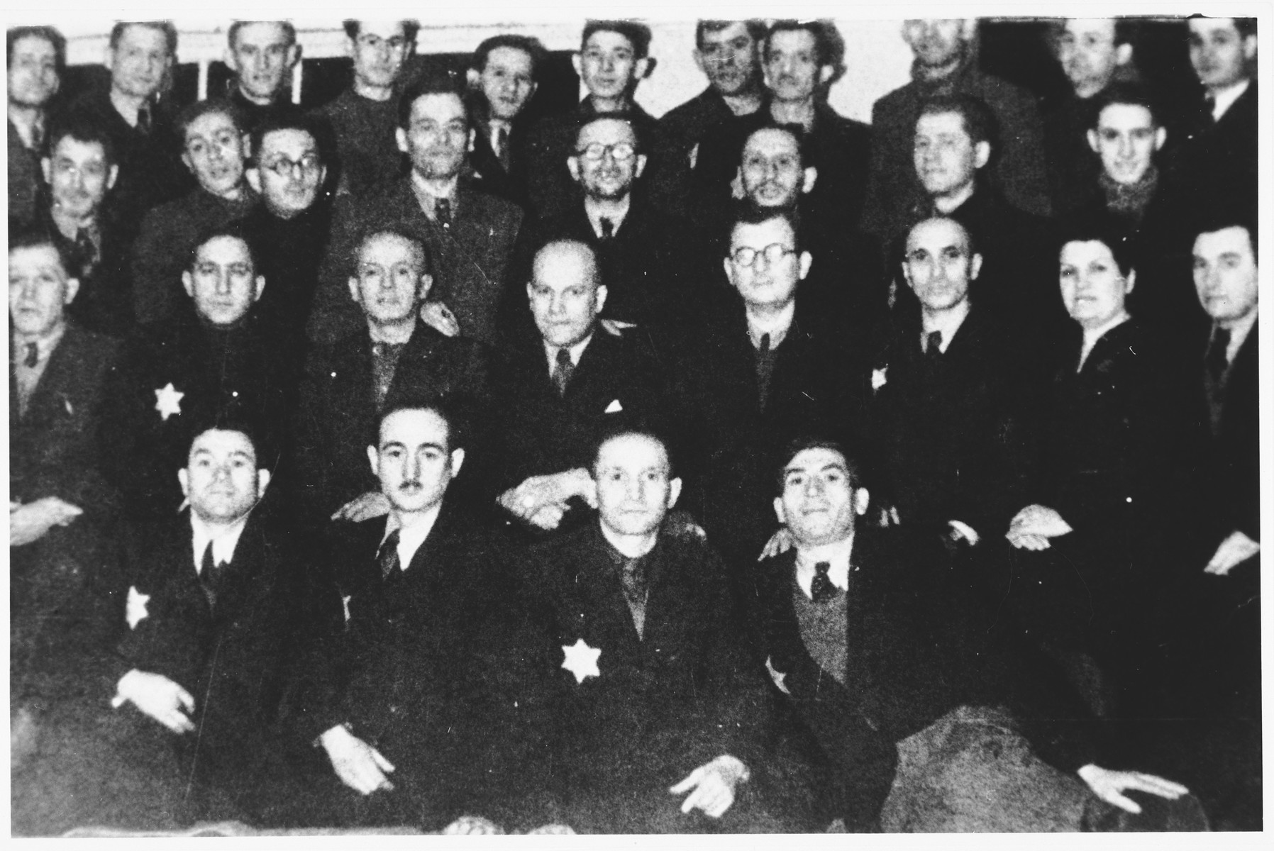 Group portrait of Jewish men in an unidentified ghetto wearing Jewish stars.