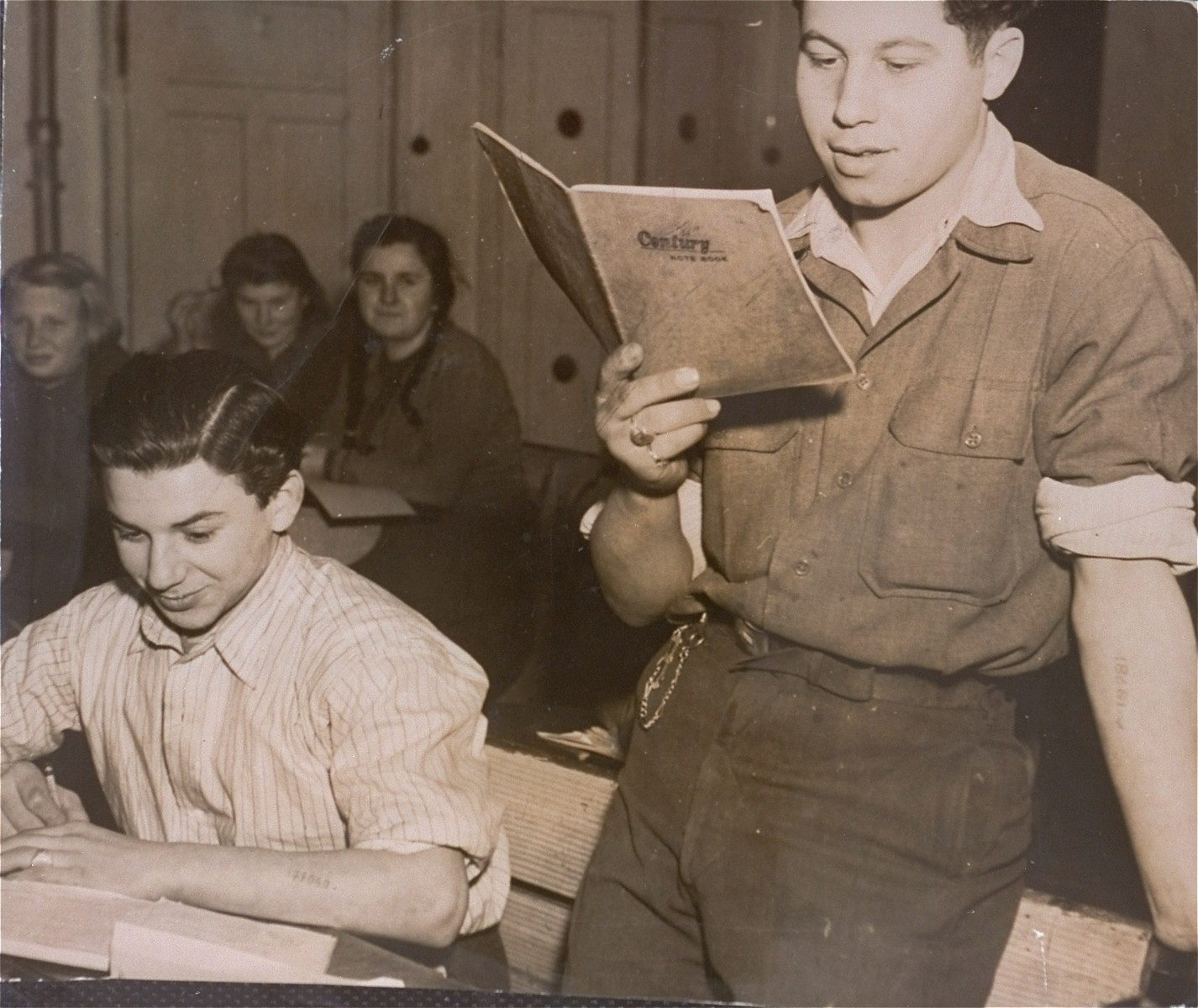 A DP youth reads to his fellow classmates at the Kloster Indersdorf DP children's center.

Standing on the right is Jakob Bulwa, a child survivor of Auschwitz and Flossenbuerg.