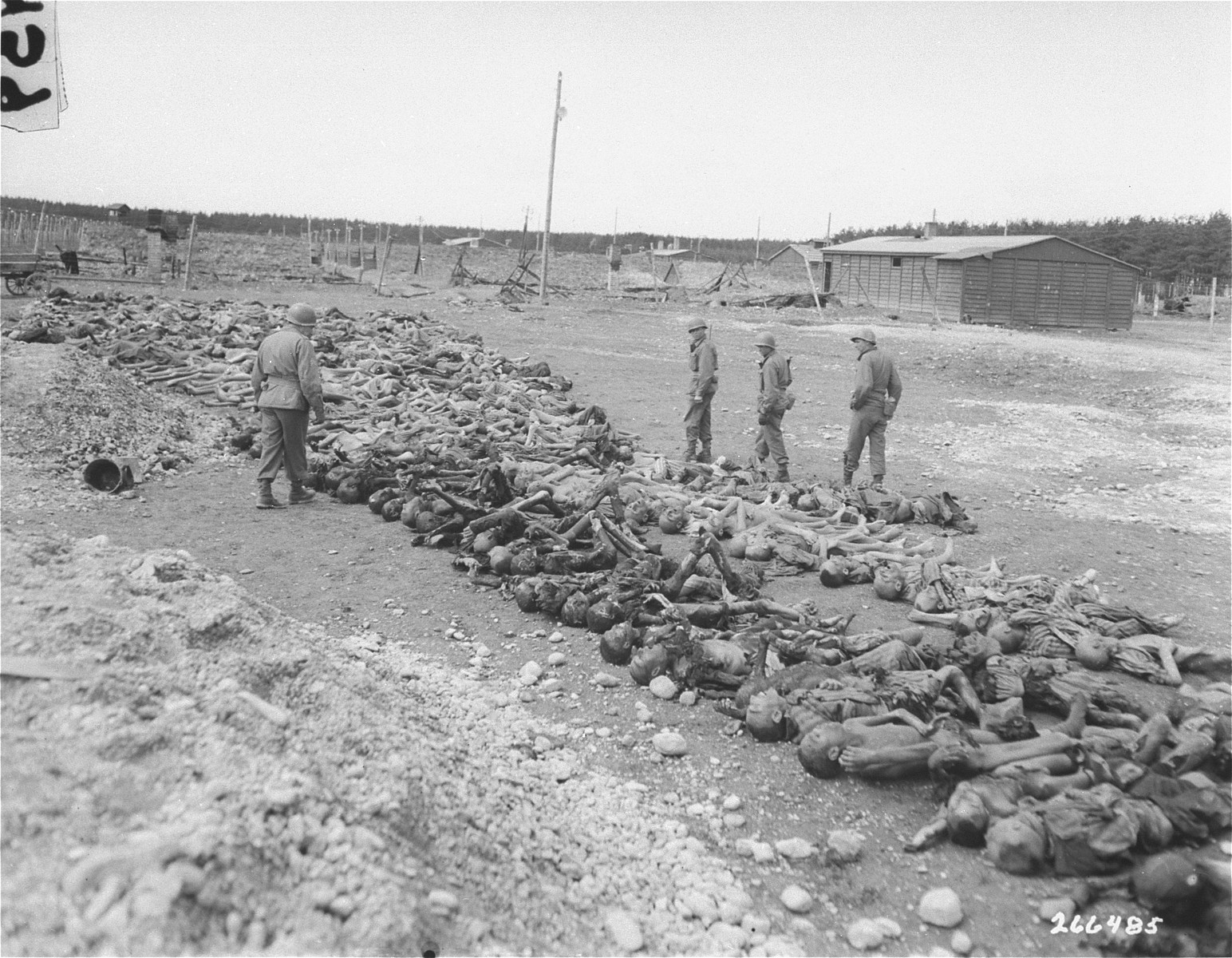 American soldiers in Kaufering IV look at the bodies of prisoners killed by the SS prior to the arrival of U.S. forces.