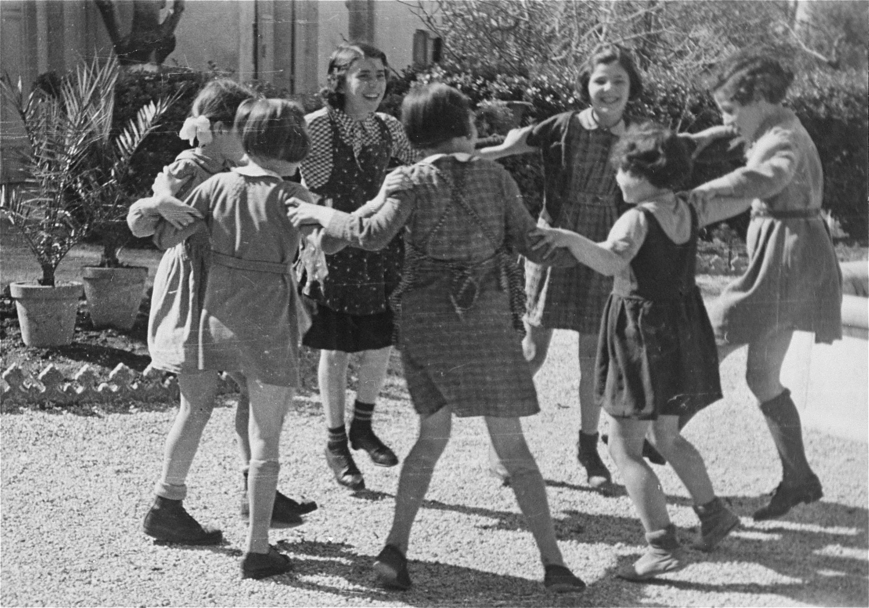 Jewish refugee children interned at the Hotel Bompard.

This photo is from a series taken by Julia Pirotte, a native of the region, who was invited by the "camp" commander to photograph the women and children because "[the] Joint [Distribution Committee] was organizing a banquet." The internees were foreign Jewish women and children intending to emigrate, but who could not do so immediately.  They were therefore interned by Vichy authorities at several hotels in Marseilles, including the Hotel Terminus, Hotel Atlantique, Hotel du Levant, and the Hotel Bompard, while awaiting visas.  Once detained, the internees faced overcrowded conditions, but often received help from the Unitarian Service Committee(USC), International Red Cross, Joint Distribution Committee(JDC), and Oeuvre de Secours aux Enfants(OSE).  Interned men were sent to the Les Milles transit camp, where those women and children who could not escape Marseilles eventually joined them in August 1942.