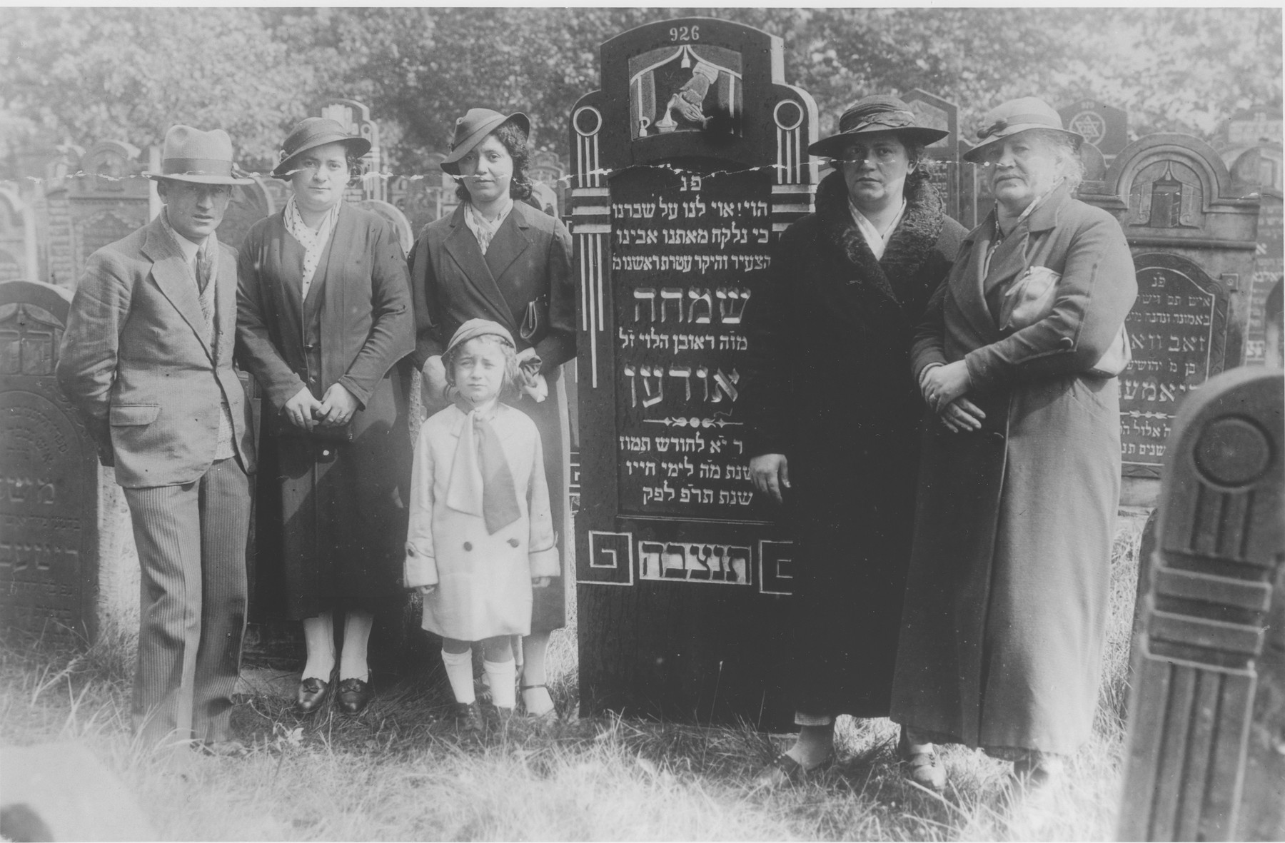 The Laudon family poses next to the tombstone of Symcha Laudon during the unveiling ceremony.

Standing from left to right are Wolf Laudon, Rywka Perla (last name unknown), Cyla Laudon, Maria Frajda's sister and Maria Frajda Laudon.