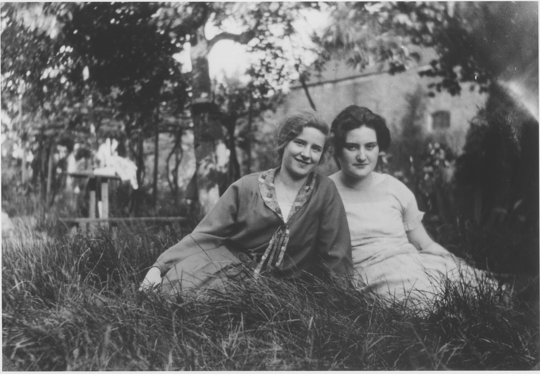 Two Jewish teenage friends sit outside in the grass.

Pictured are Hede Rube (left) and Emmi Schedel.