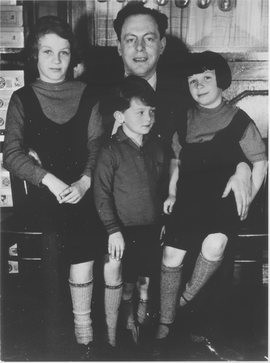 Leo Fraenkel poses with his nieces and nephew in the Erlanger shoe and dry goods store in Guntersblum, Germany.

The children pictured are Margo, Fritz and Hannelore Erlanger, the children of store owner, Lothar and Minna (Heis) Erlanger.  Leo Fraenkel was married to Lothar's sister.