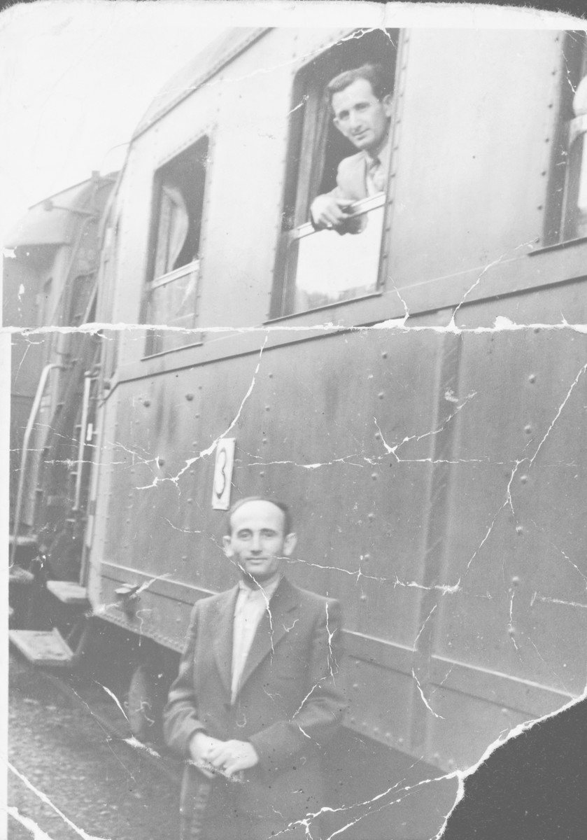 Two brothers pose in and outside a train [possibly in Muehldorf].

Pictured looking out of the train window is Simon Ruder.  Standing next to the train is his brother Mendel.