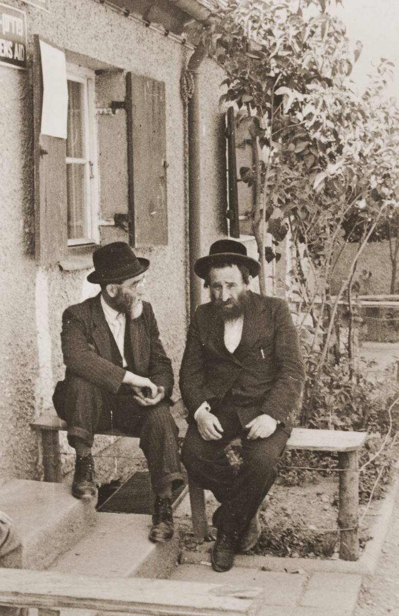 Two religious Jewish DPs sit outside a welfare office in the Neu Freimann displaced persons camp.