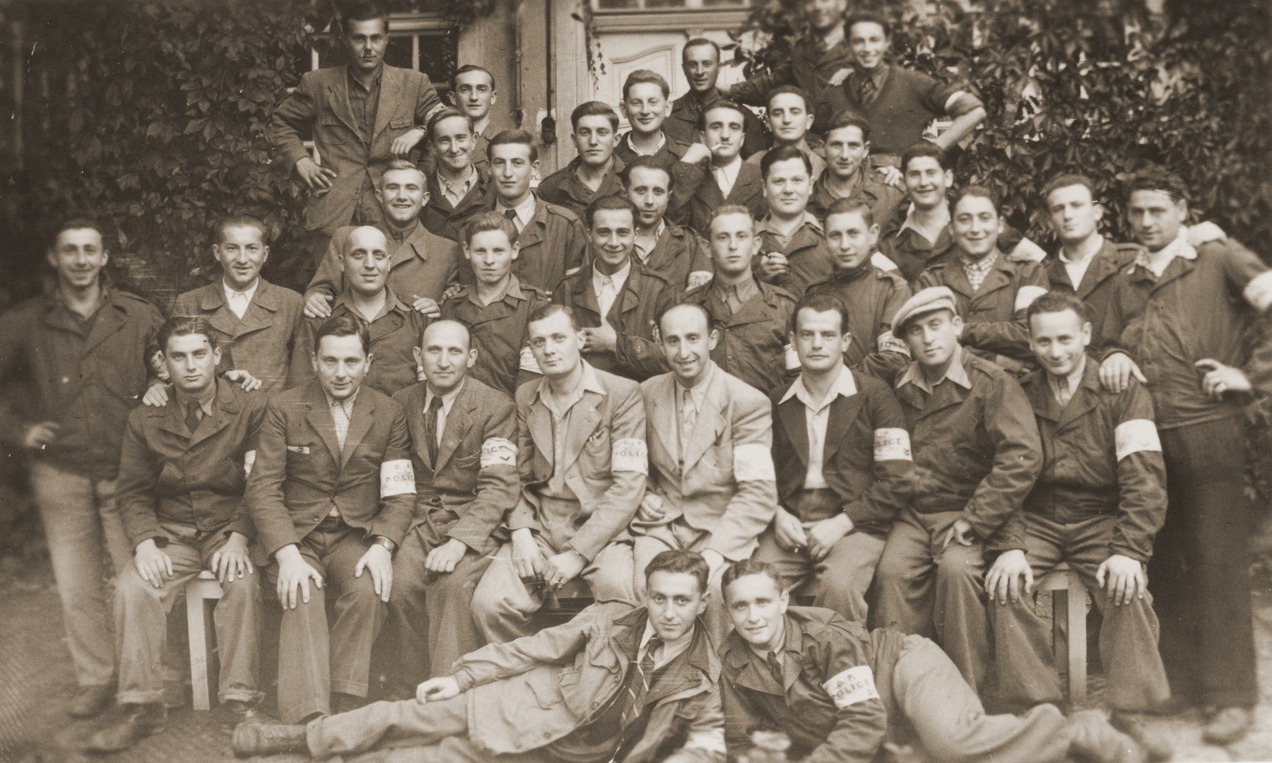 Group portrait of Jewish police in the Landsberg displaced persons camp.

Among those pictured is Moshe (Morris) Barkowski, in the third row (first row standing), fifth from the left. Henry Vogelhut is pictured in the center back, with a short mustache and a cigarette in his mouth.