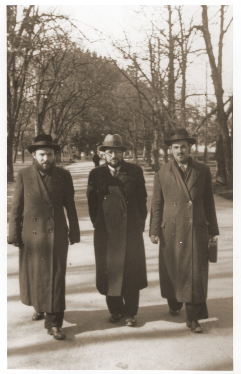 Szmuel Icek Rotsztajn walking with two friends.  

Rotsztajn was an orthodox Jewish publicist, novelist and short story writer, who was co-editor of "Dos Yiddishe Tagblat" and editor of the orthodox literary journal "Der Flaker".