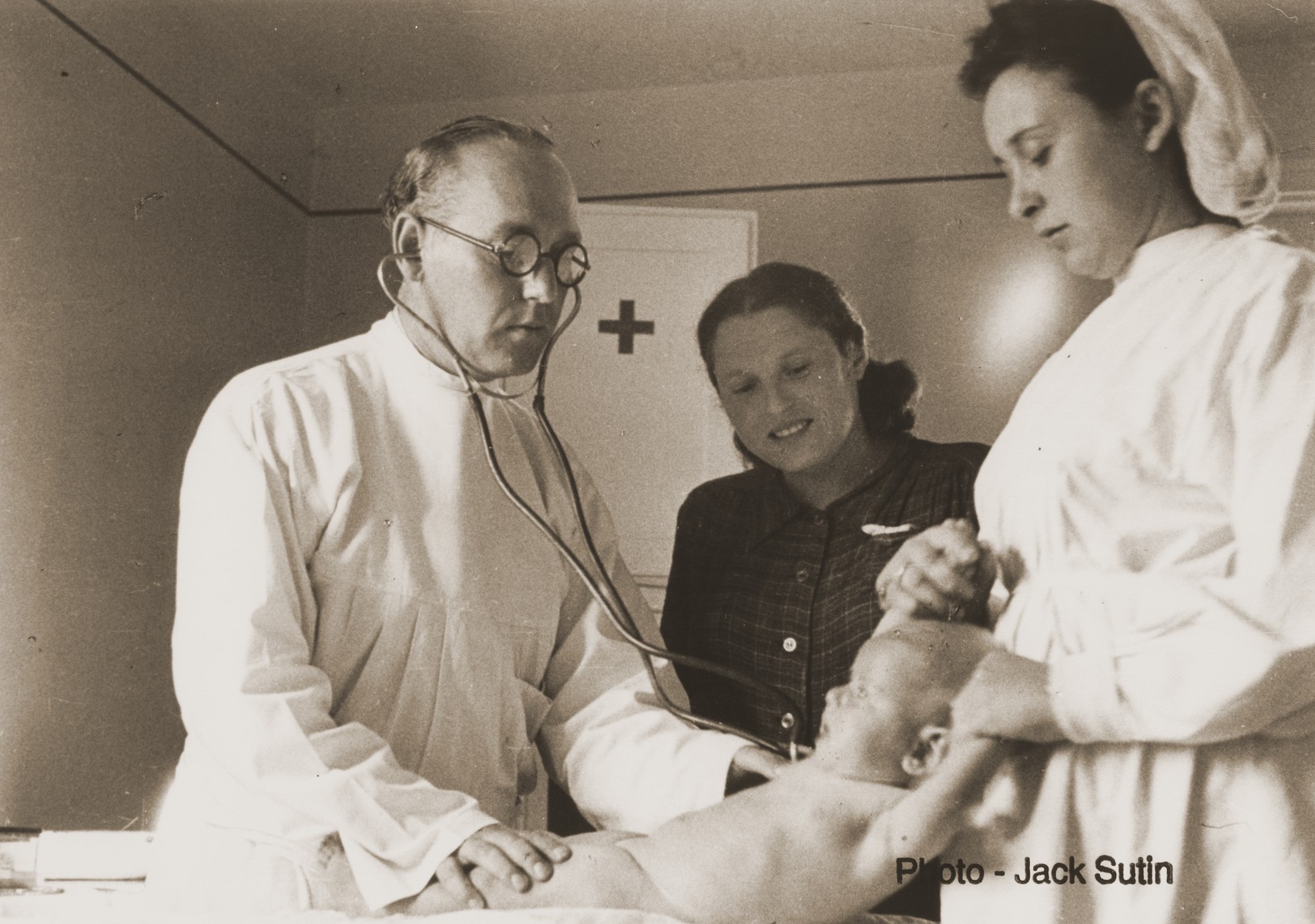 An infant is examined by a doctor and nurse at the infirmary in the Neu Freimann displaced persons camp.