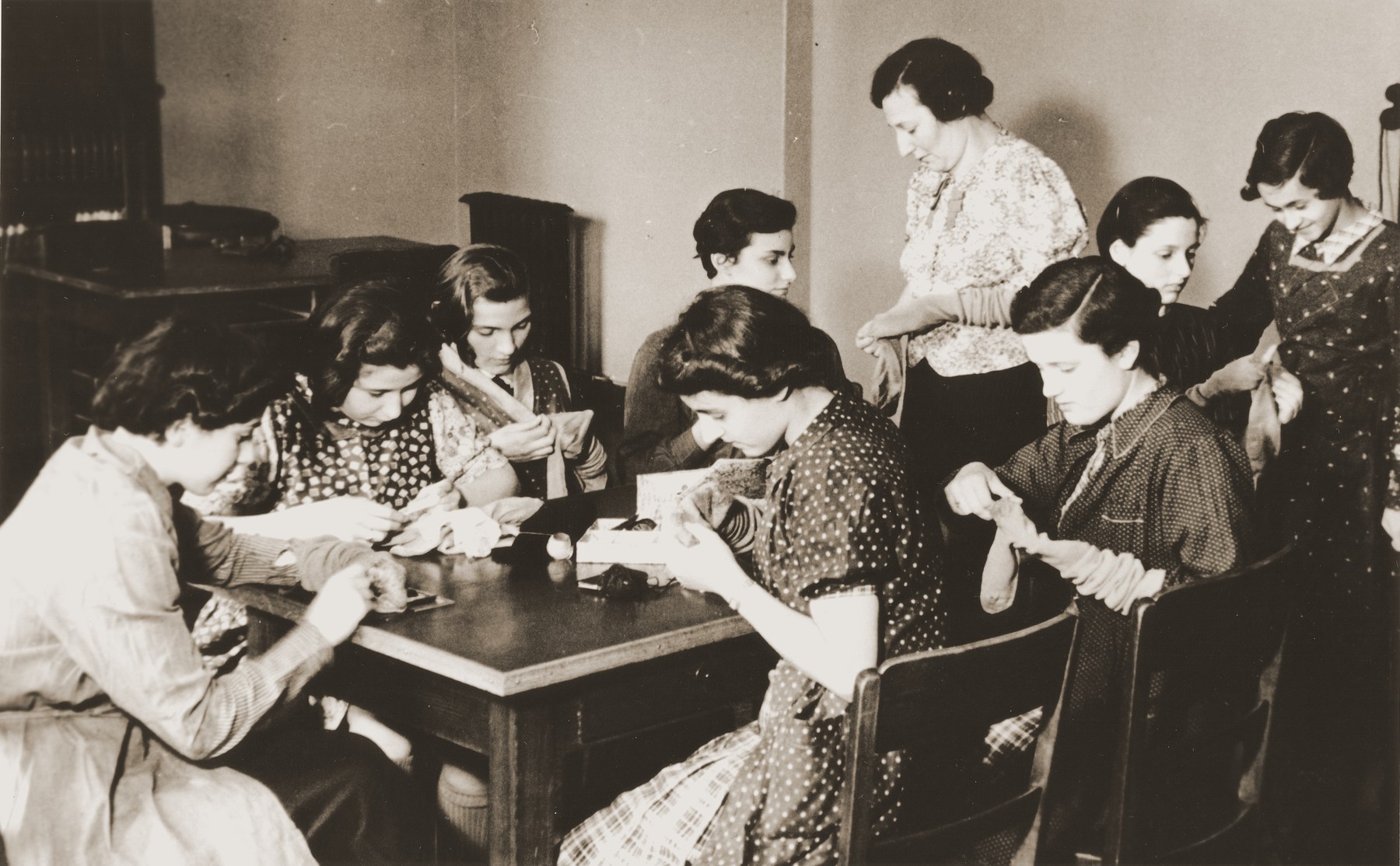 Teenage girls darn socks for the boys of the Baruch Auerbach Jewish orphanage in Berlin.

Margot Peretz is pictured in the front, right.