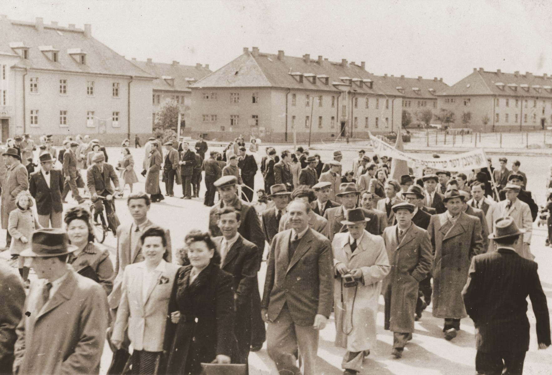 Demonstration demanding that the Jews be let into Palestine in the Belsen DP camp.  In the back are the former officer baracks.

Dora Friedfertig is standing in the front  linking arms with Zosia Weinman.  Behind them are Shmuel Weinman and Walter Loberstein.