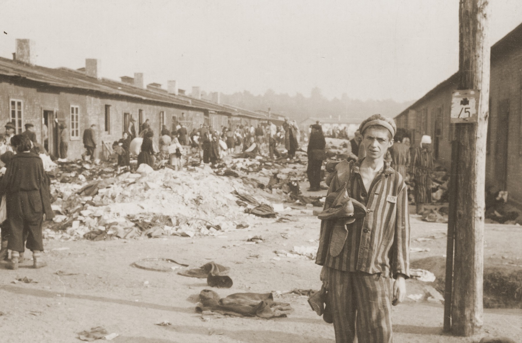 Survivors in Bergen-Belsen wander outside the barracks.