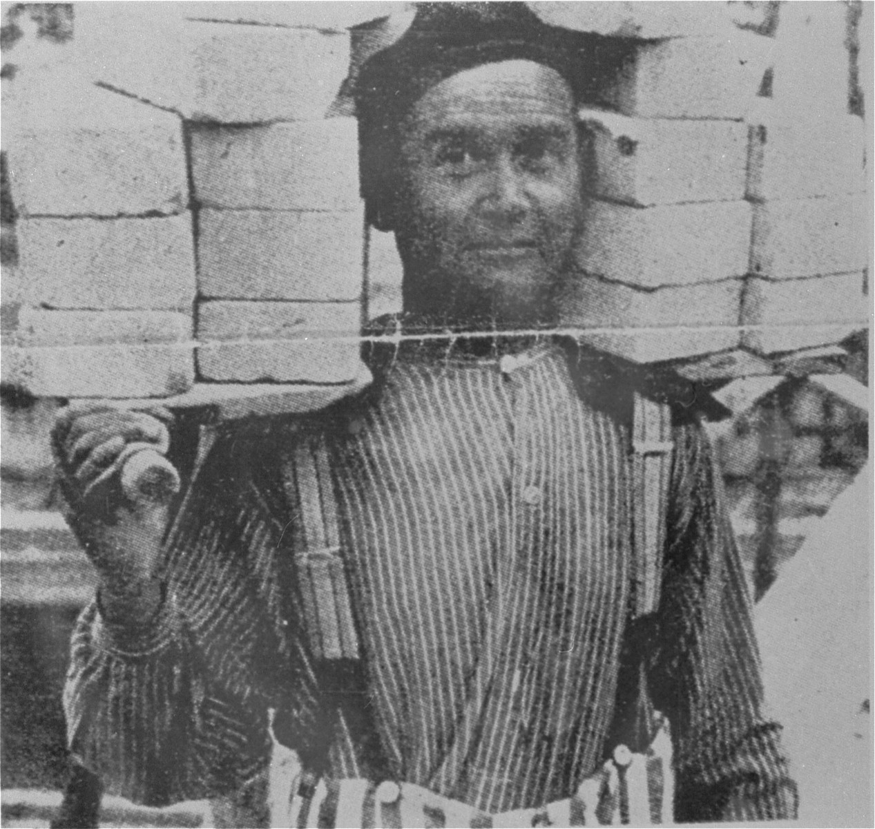 Propaganda photo of a prisoner in Dachau at forced labor.  

The caption which originally appeared with this Nazi propaganda photograph read: "A load of bricks is lighter then the burden of the crime - appreciation for achievement is taught".