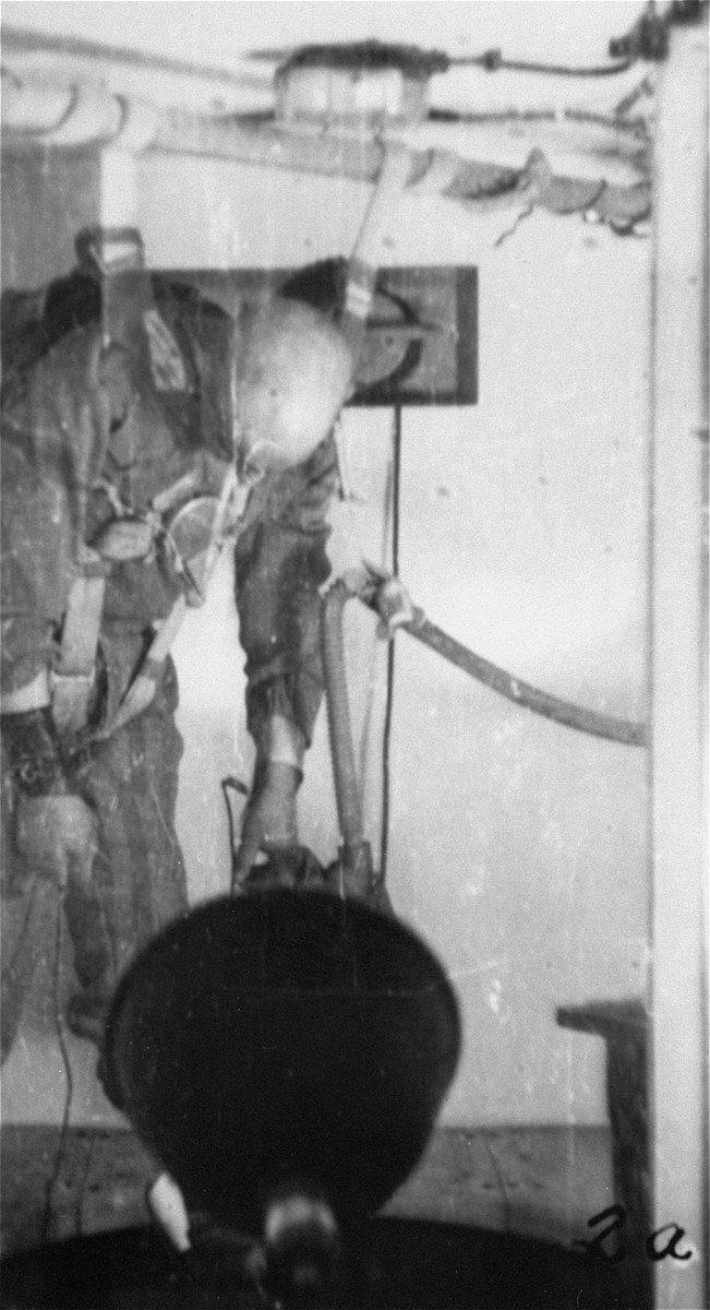 A prisoner in a special chamber who has been subjected to low pressure experimentation falls into unconsciousness.  For the benefit of the Luftwaffe, air pressures were created comparable to those found at 15,000 meters in altitute, in an effort to determine how high German pilots could fly and survive.