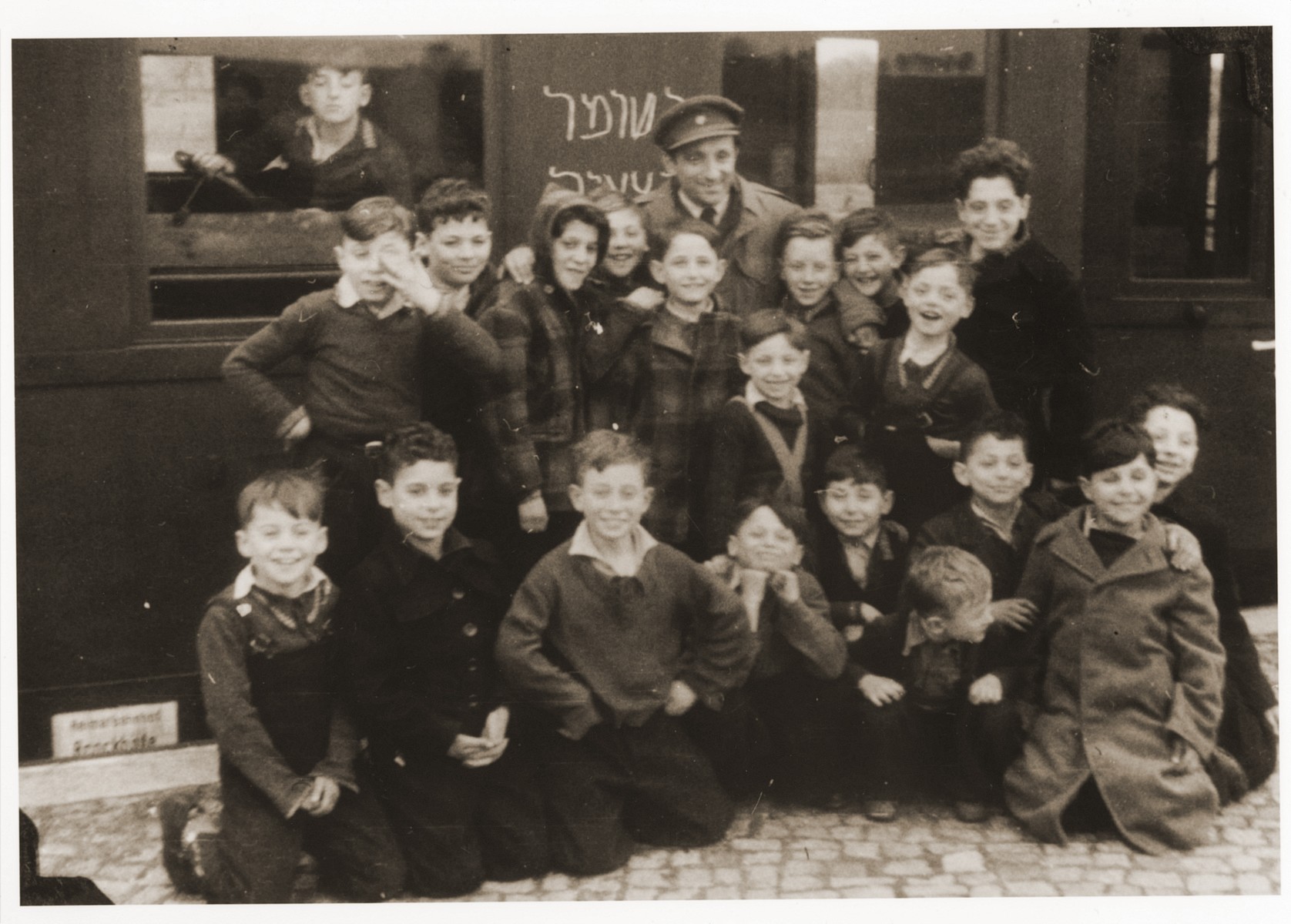 Children from the JDC children's home in Blankenese pose in front of a train in the Bergen-Belsen station before their departure for Palestine.

Chalked on the train in Hebrew are the words, Hashomer Hatzair, the name of a Zionist youth movement.