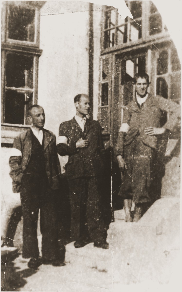 Three brothers wearing armbands pose on the stairs outside the carpentry workshop in the Berezhany ghetto. 

Pictured are Oskar, Herman and Theodor Perl, the brothers of the donor, Rose Perl.