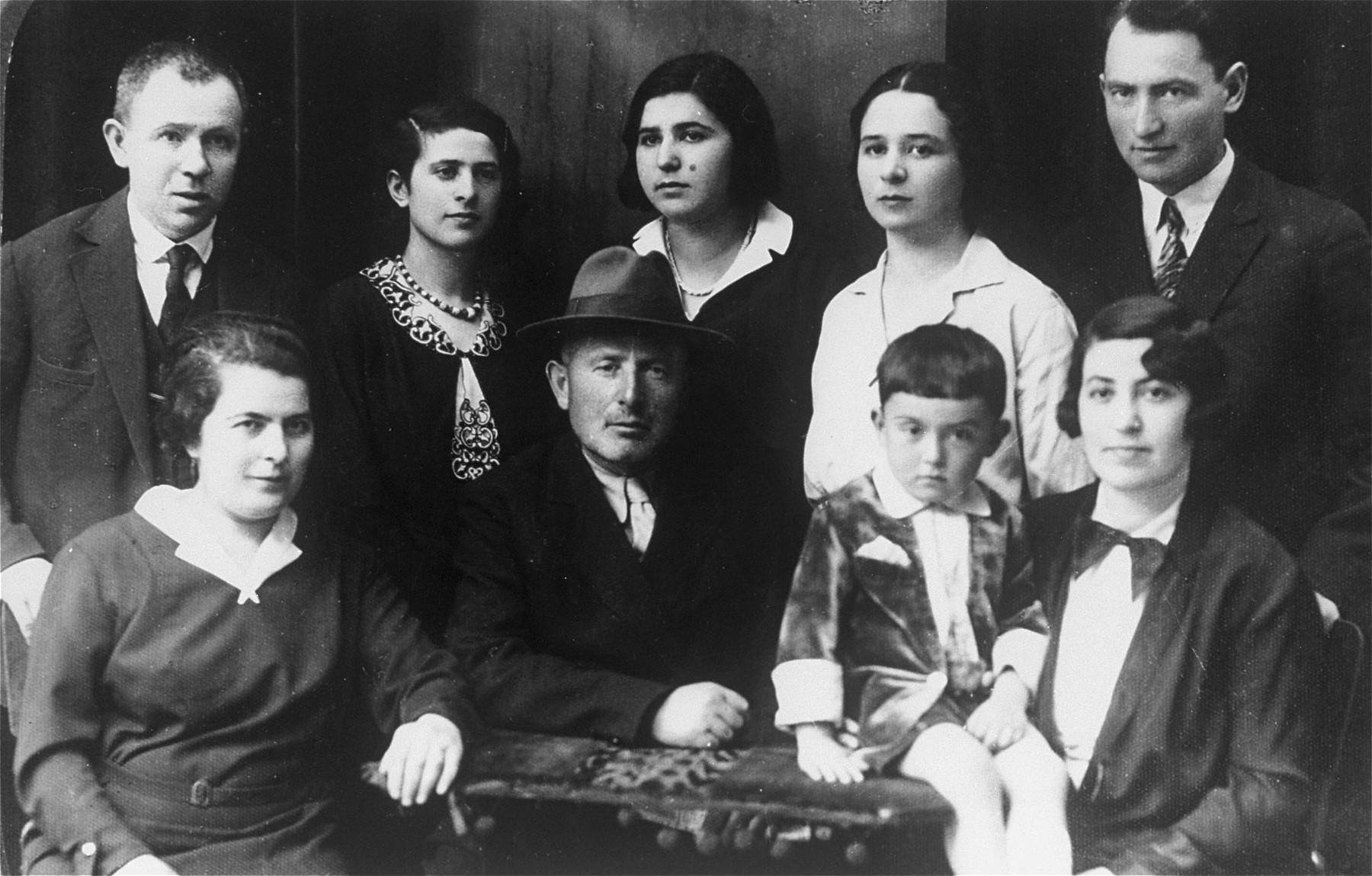 Studio portrait of members of a Jewish family in Vilna.

Pictured are members of the Rudashevsky family.  Among those pictured are: Rosa Rudashevsky (standing second from the left), her father, Zvi Yaacov Rudashevsky (front row center with hat), her sister Yona Rudashevsky (back row, second from the right), Hannah Rudashevsky (back row, center), and Eli Rudashevsky (back row, right), his wife Rosa (a second Rosa, front row, right) and son Yitzhak (front row, second from the right).
