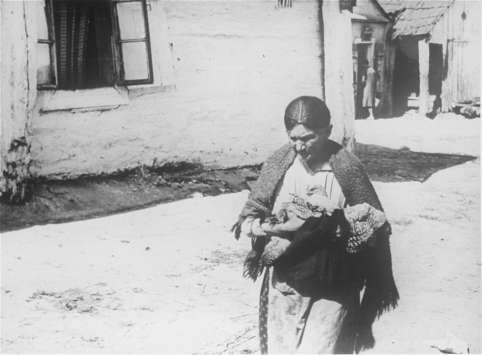 Jewish woman carrying fowl in the street of Kazimierz Dolny.