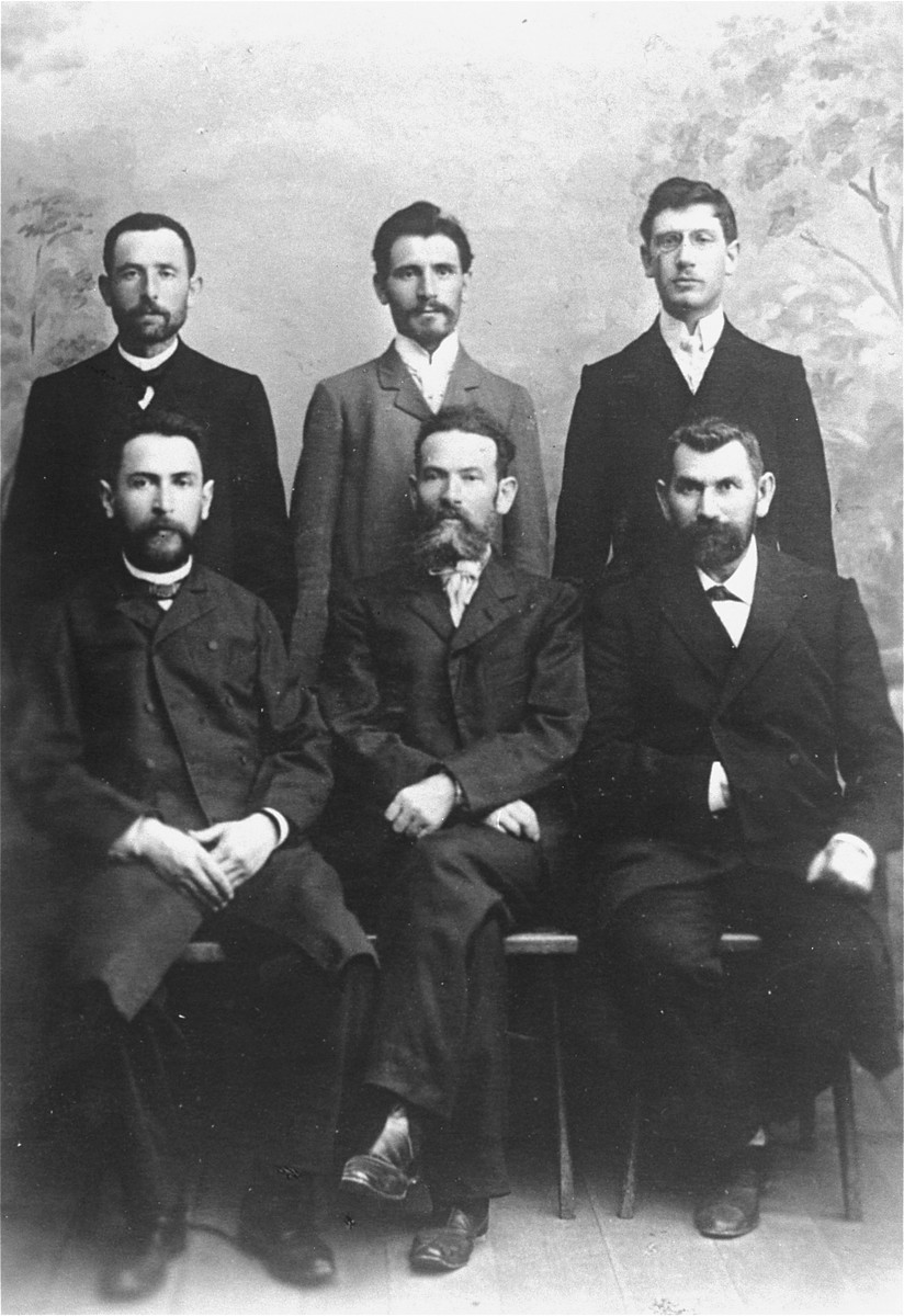 Studio portrait of six Jewish men in Vilna.

Pictured are Abram Magid and his five brothers-in-law.  Among those pictured are Hirsch-Jankl Rudashevsky (top row, left); Cantor Hirsch Ass; Abram Magid, (chief accountant, top row, right); Feivel Garber (owner of the printing plant where the first Hebrew books sent to America were printed); Feodor Mikolayevsky (engraver to the Czar, front row, center); and Leib Eppel (who attended the first Zionist Congress in Basel, front row, right).