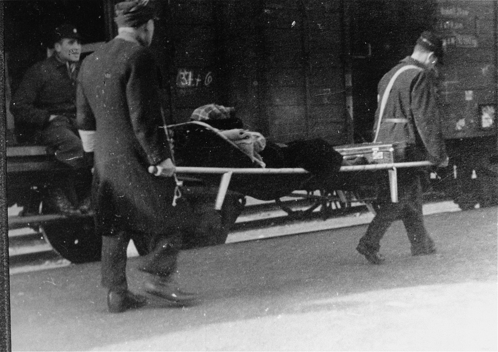 Members of the Ordedienst (Jewish police) assist in the deportation of an elderly woman from Westerbork.